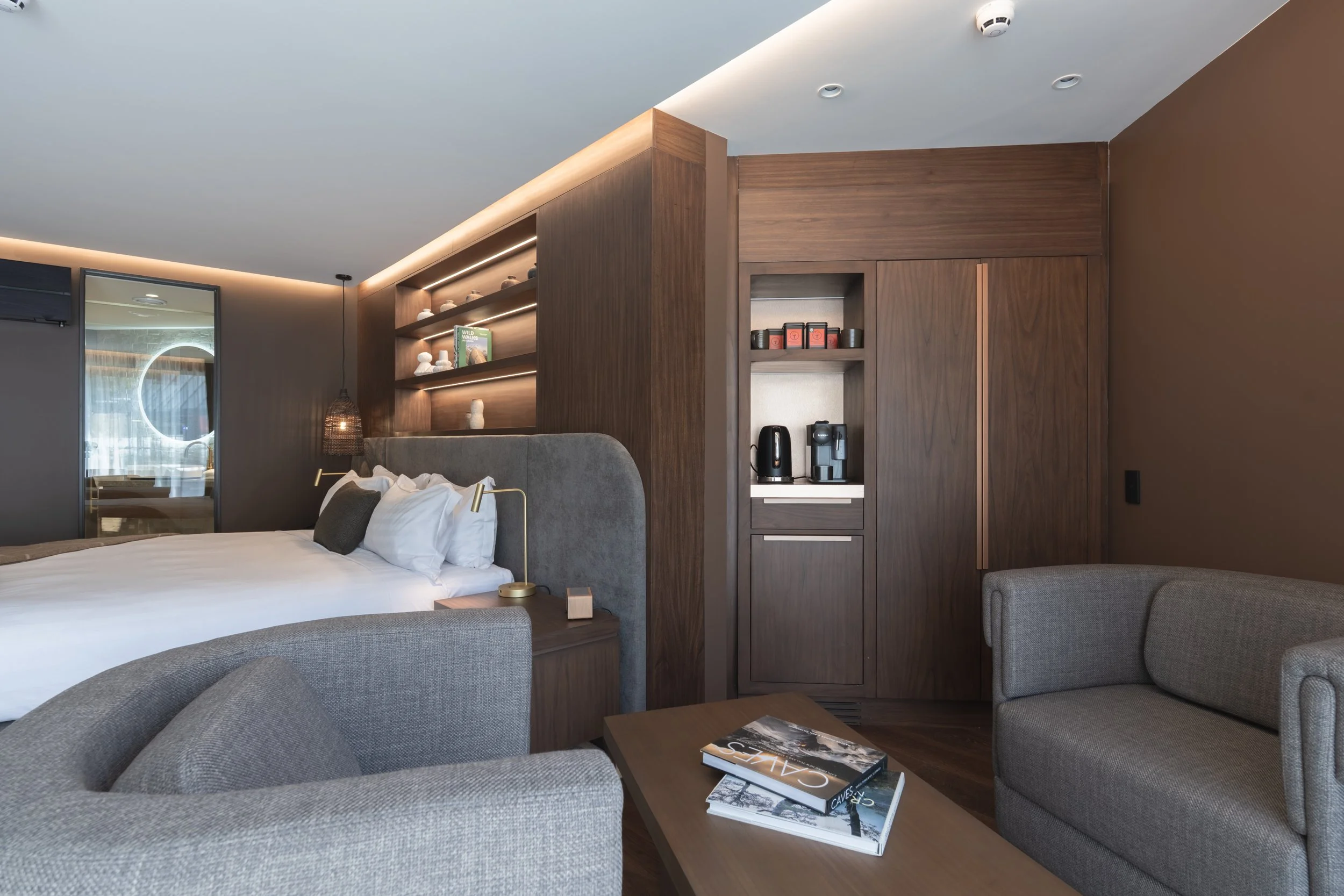 Spacious guest room with seating area, minibar and warm timber interiors.