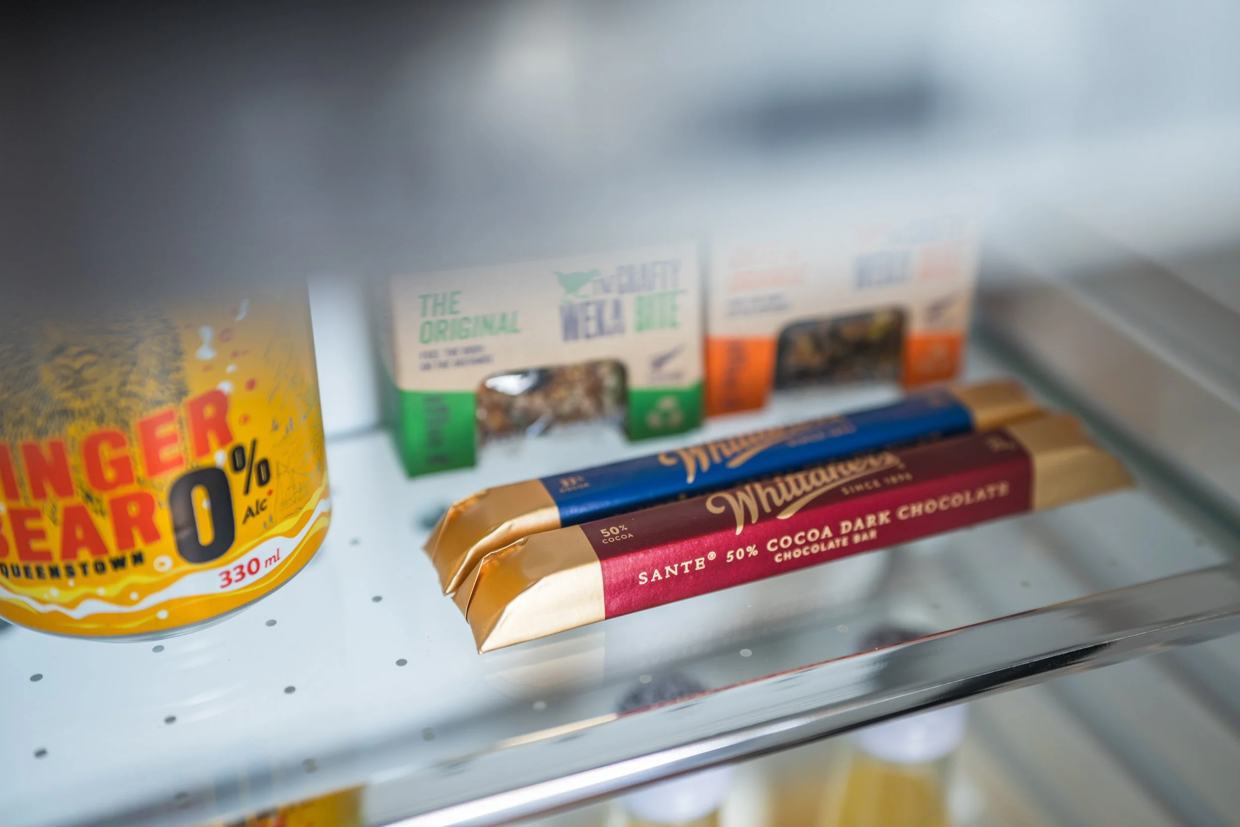 Minibar fridge with snacks and beverages neatly arranged.