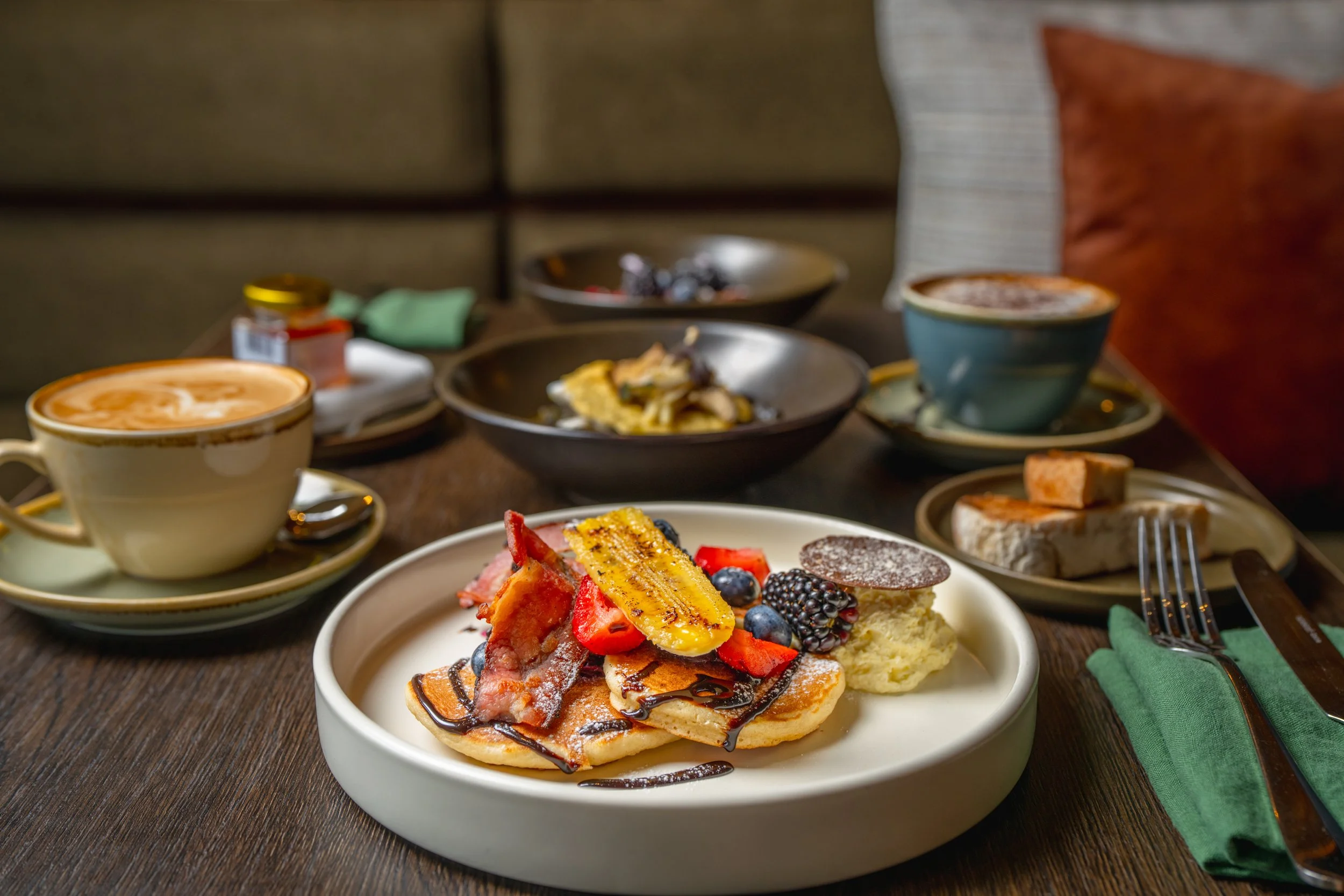 Gourmet breakfast table including coffee, pancakes, granola.