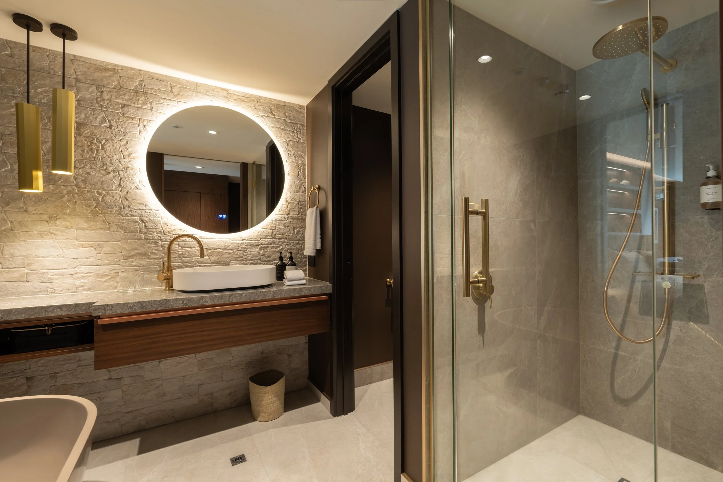 Contemporary bathroom with walk-in shower, stone tiles and timber finishes.