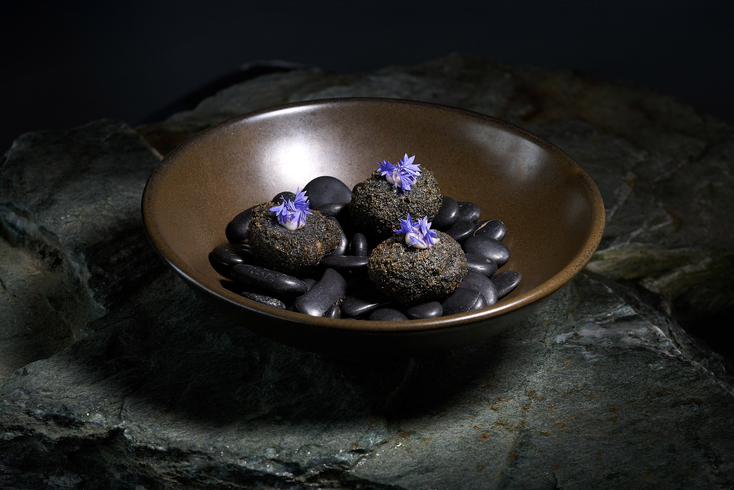 Elegant plated dessert at Elevation Bar & Restaurant Queenstown with dark chocolate and edible flowers.