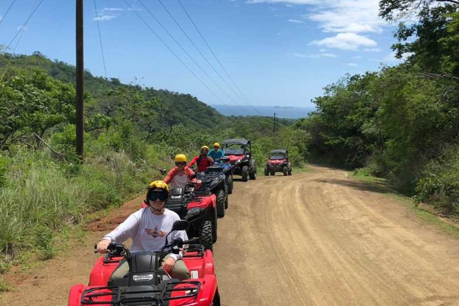 A group of tpurists driving ATV,s. they are doing a line of ATVs, one behind the other