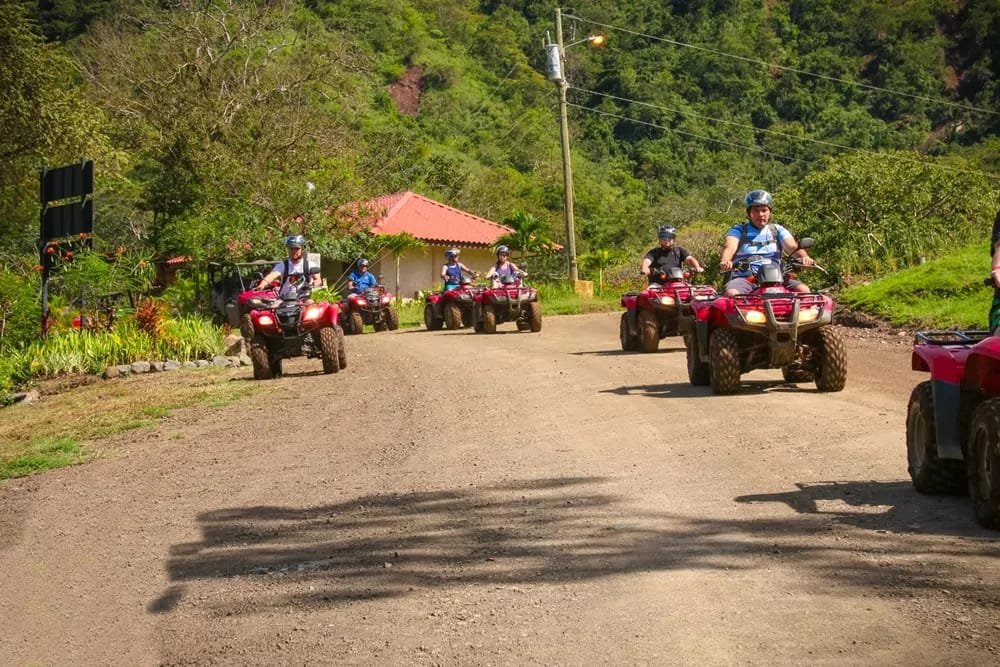A group of tourist driving ATV,s toward the camera, in a tropical enviroment of Costa Rica