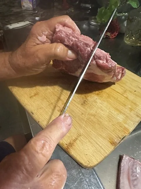 a piece of pork is being cut on a cutting board