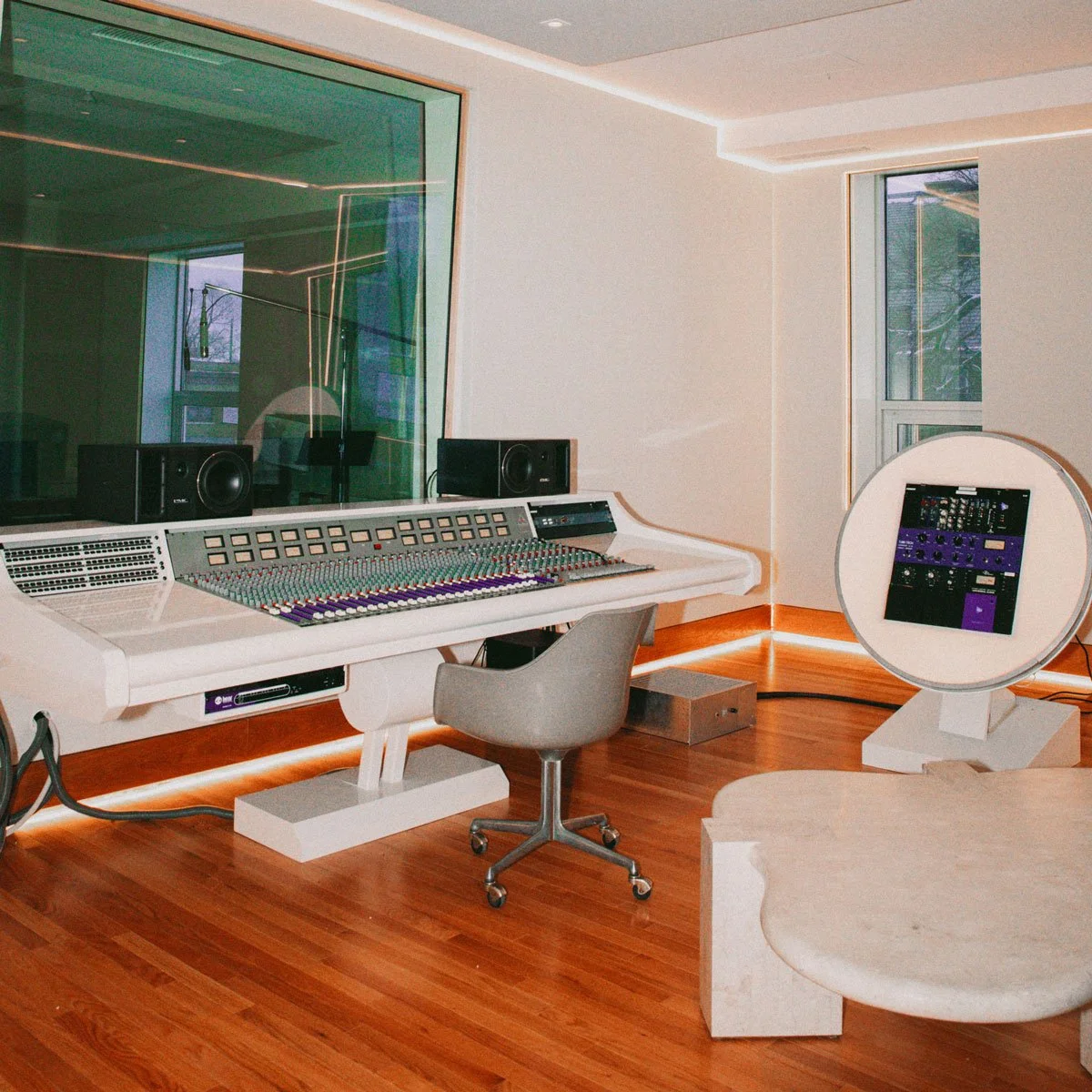 A view of the Assemble Sound recording studio in Detroit showcasing the console, coffee table, and chair.