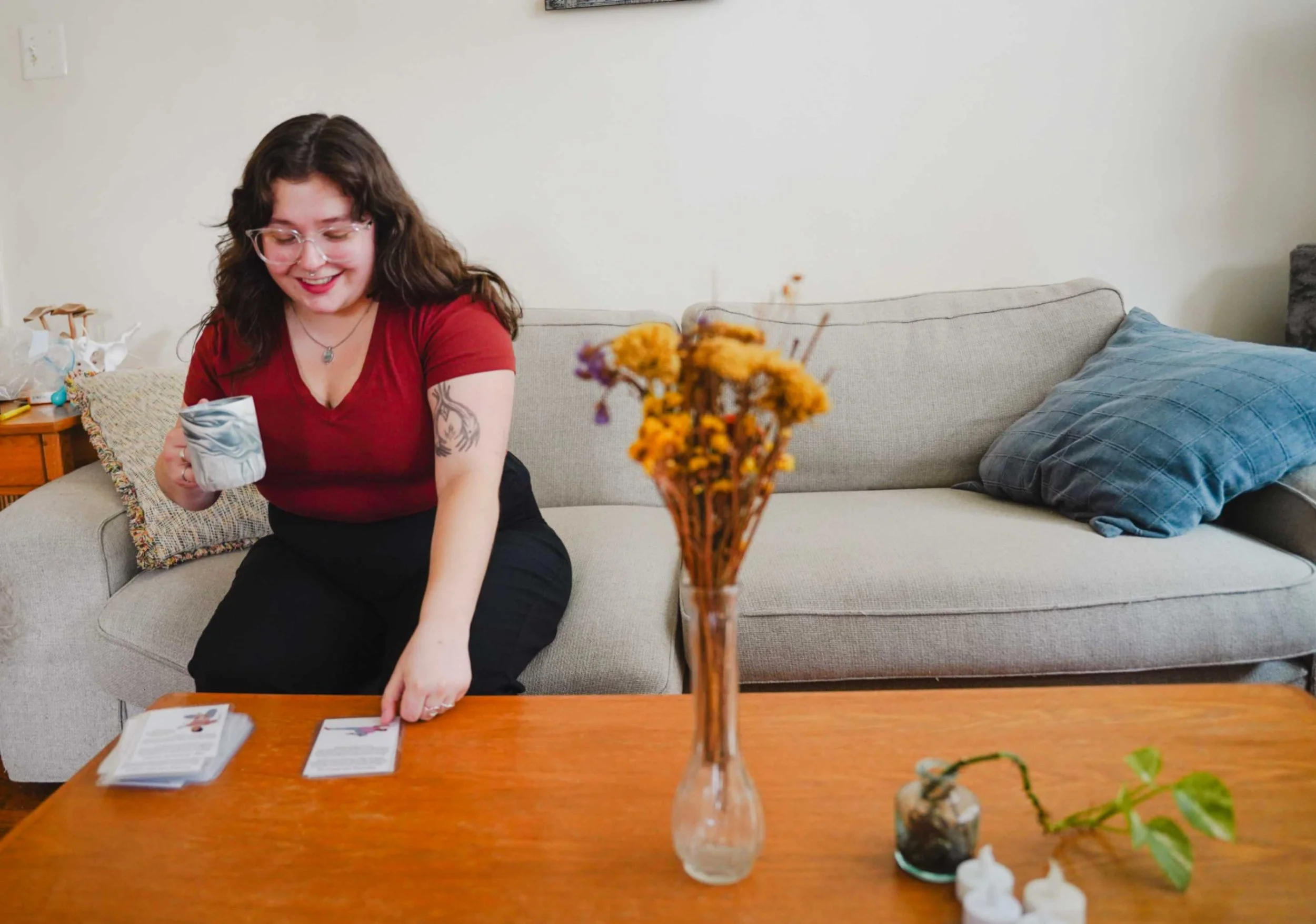 doula drinking coffee and smiling looking at cards with positions for labor and birth