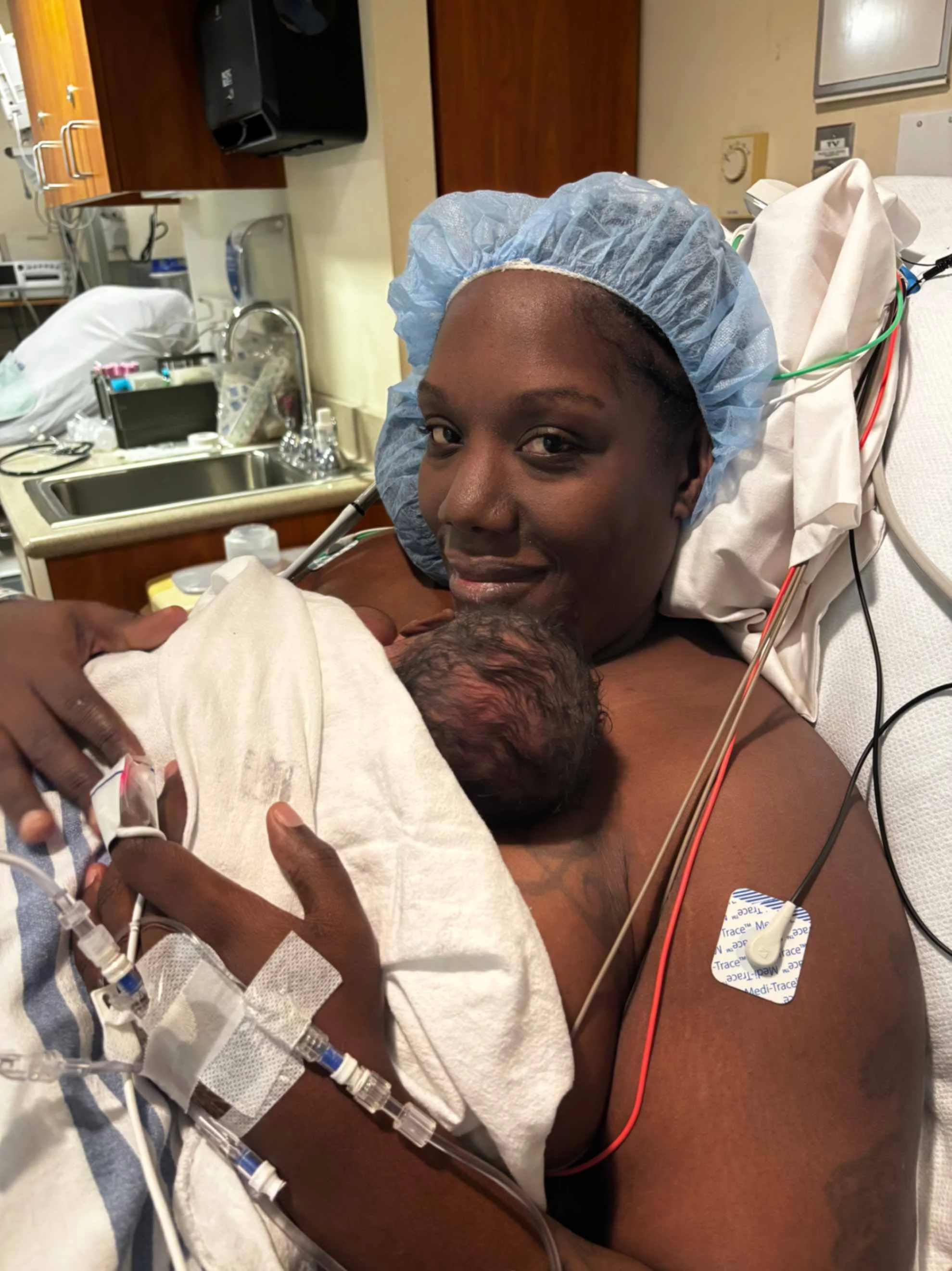 doula client holding her baby skin to skin after giving birth in a hospital