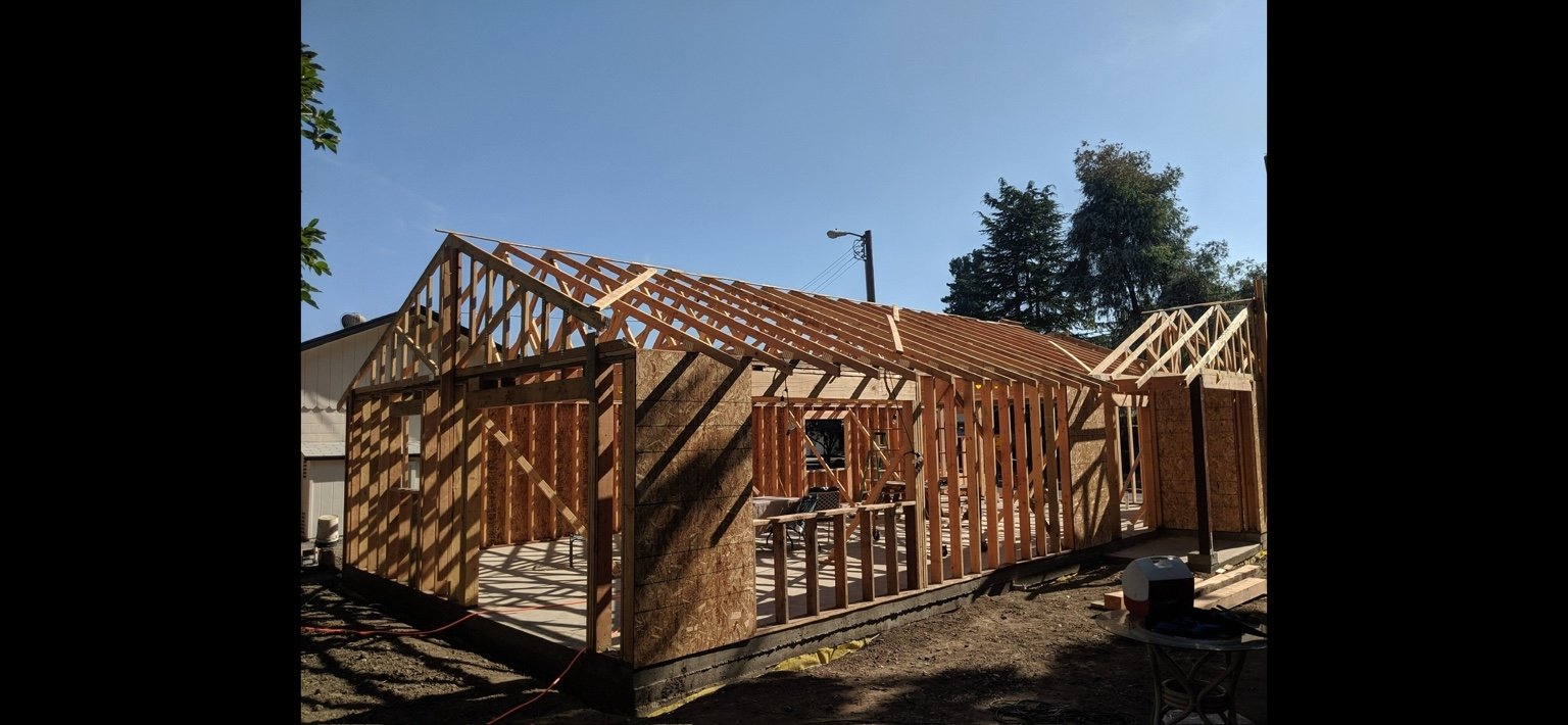 Residential roof framing and wood-framed walls during rough carpentry.