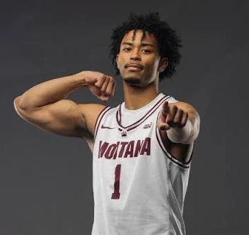 A basketball player in a white jersey with 'Montana' and number 1, pointing at the camera, flexing his right arm.