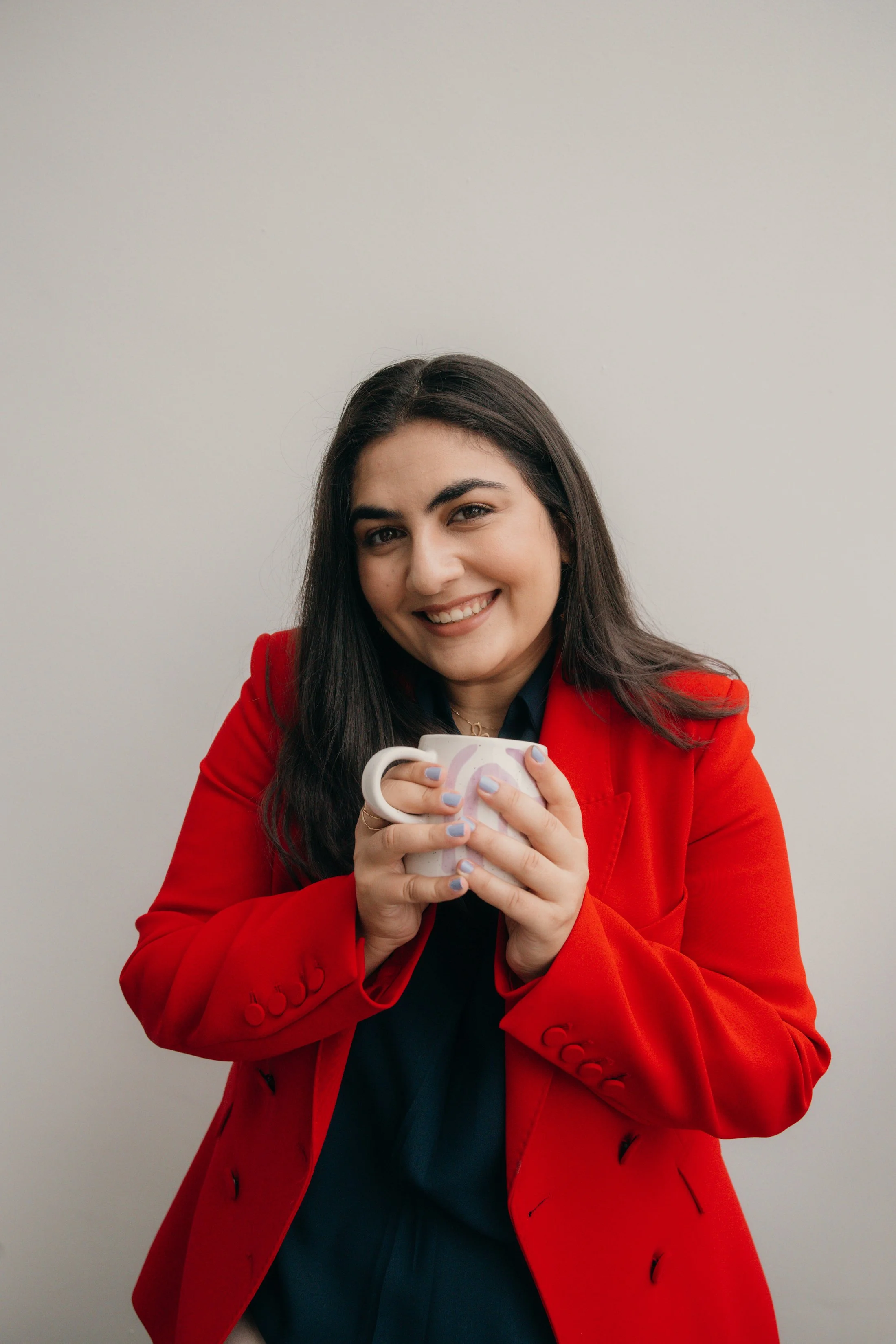 Karen wearing red blazer with mug in hand