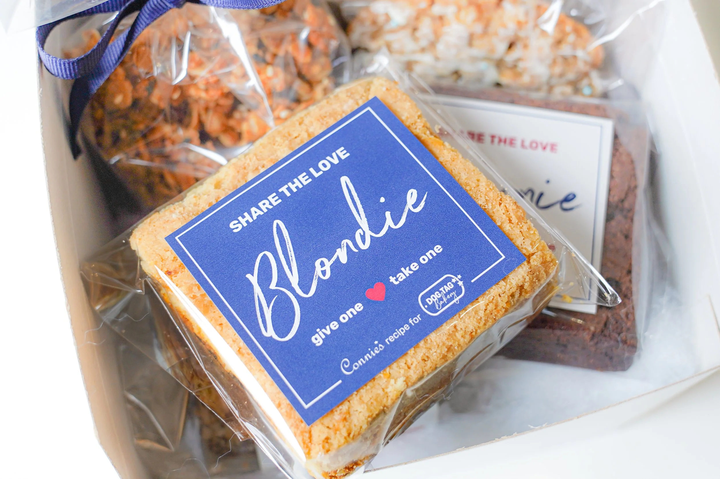 Close-up of assorted baked goods in packaging, including a blondie with a "Share the Love" label.
