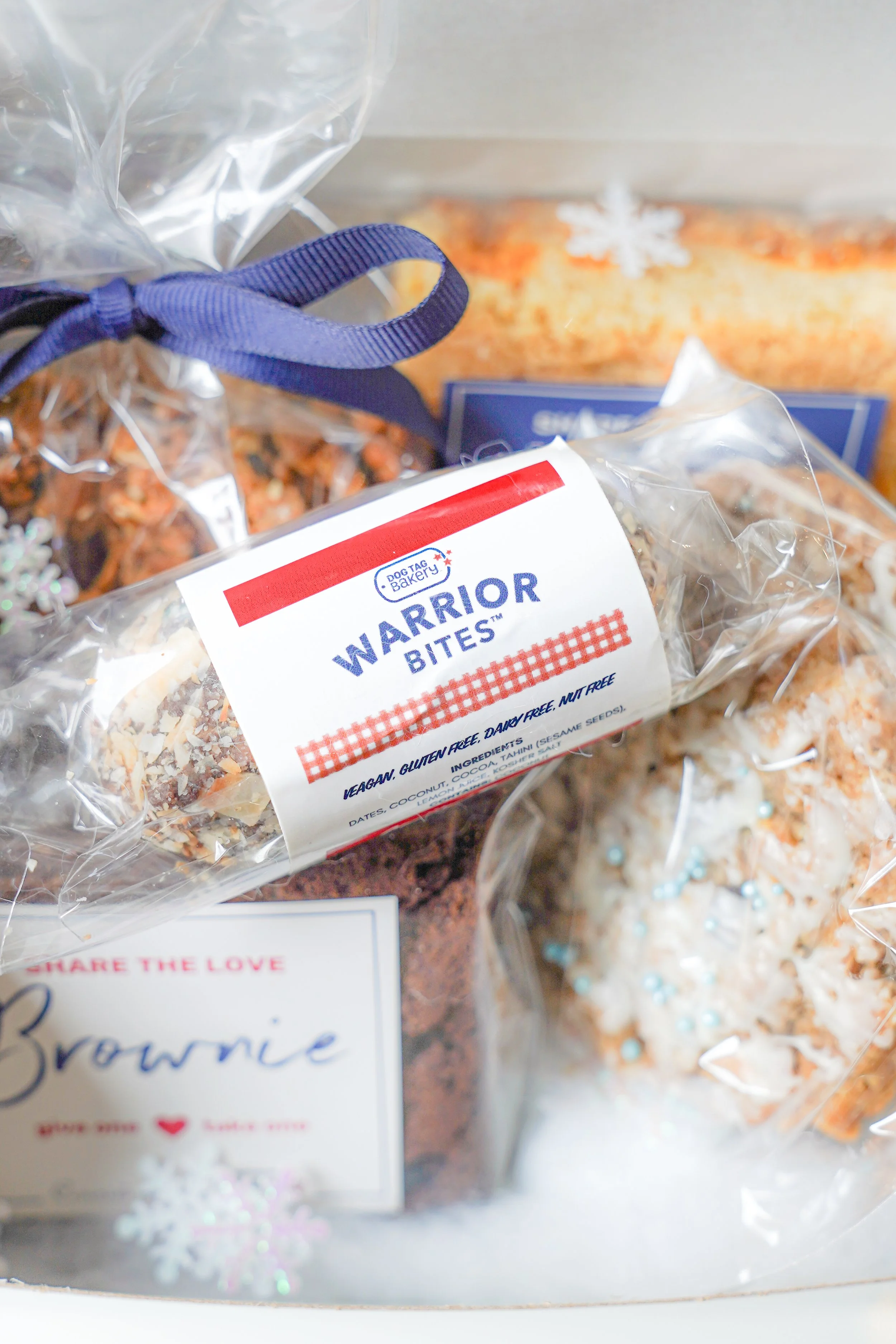 Assorted baked goods in a gift box, featuring Warrior Bites and brownies.
