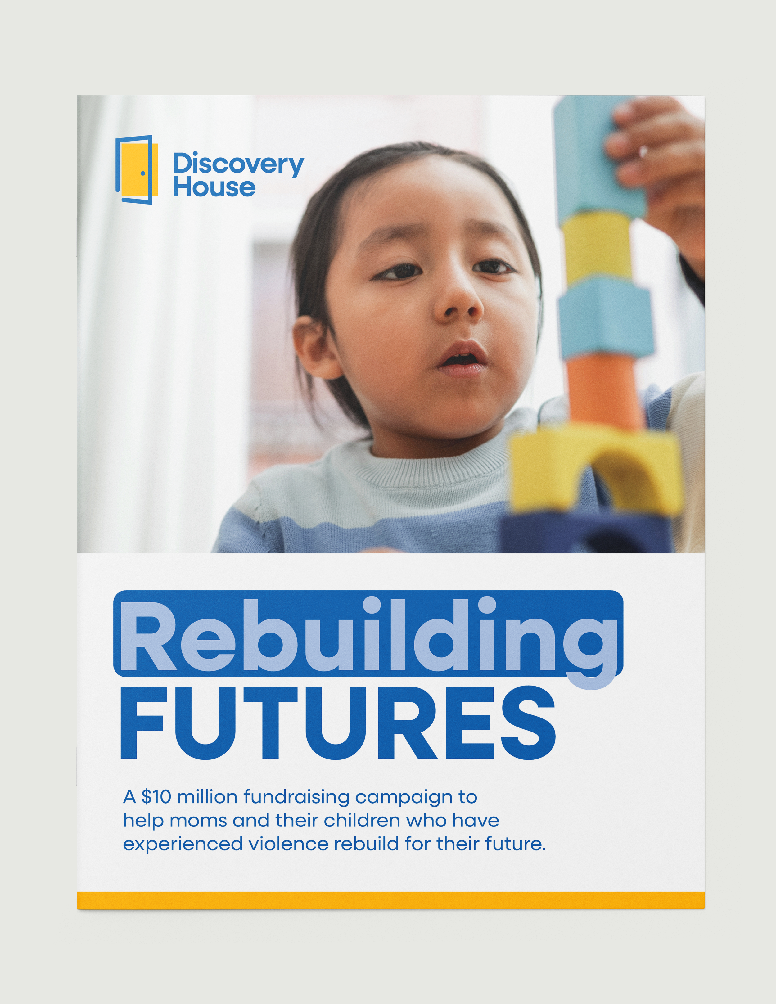 Graphic Design: Cover of the Rebuilding Futures Campaign Report for Discovery House featuring a child playing with blocks.