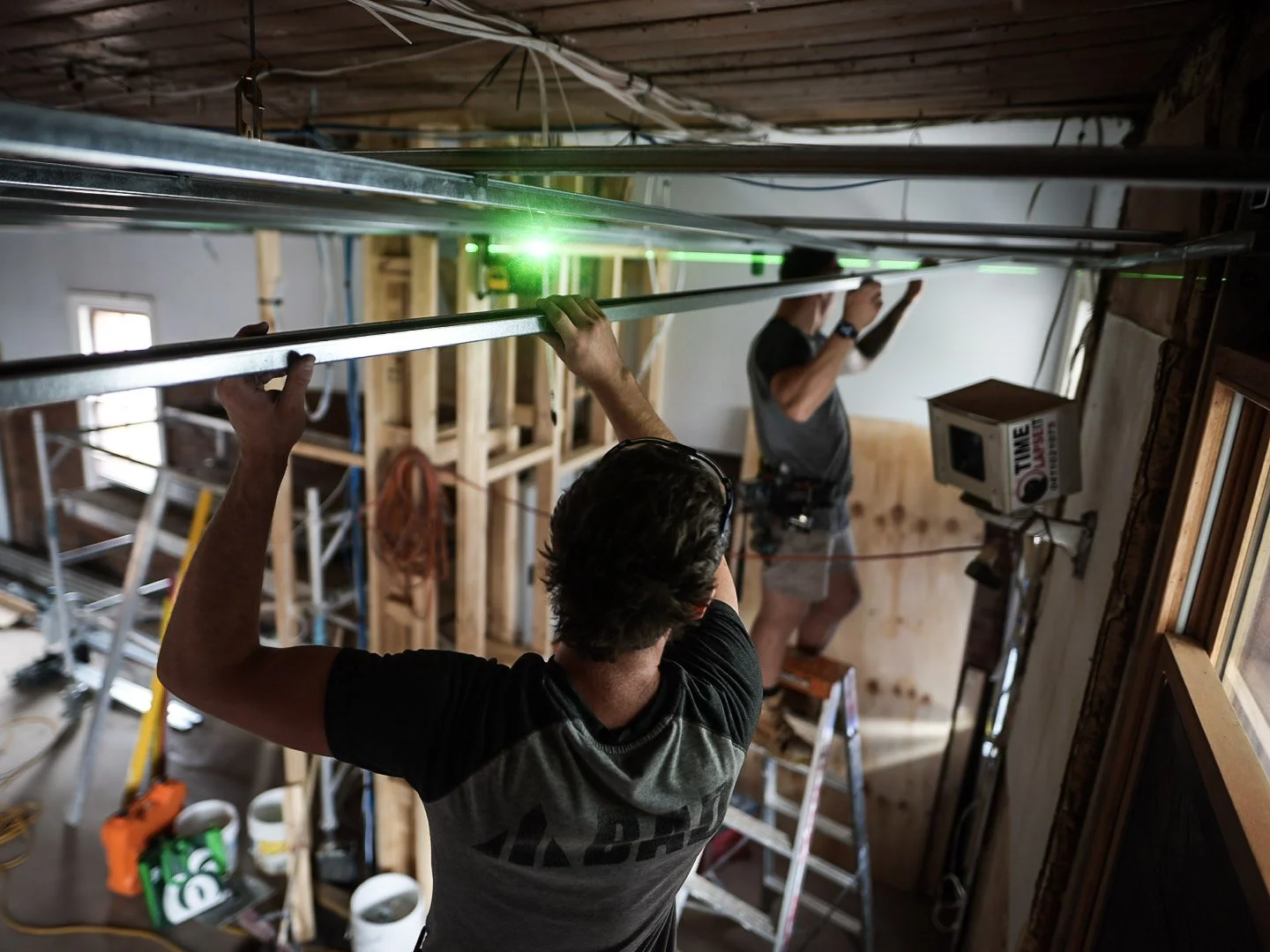Two workers installing a suspended ceiling for commercial renovation