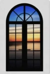 A colorful sunset or sunrise viewed through a large arched window with panes