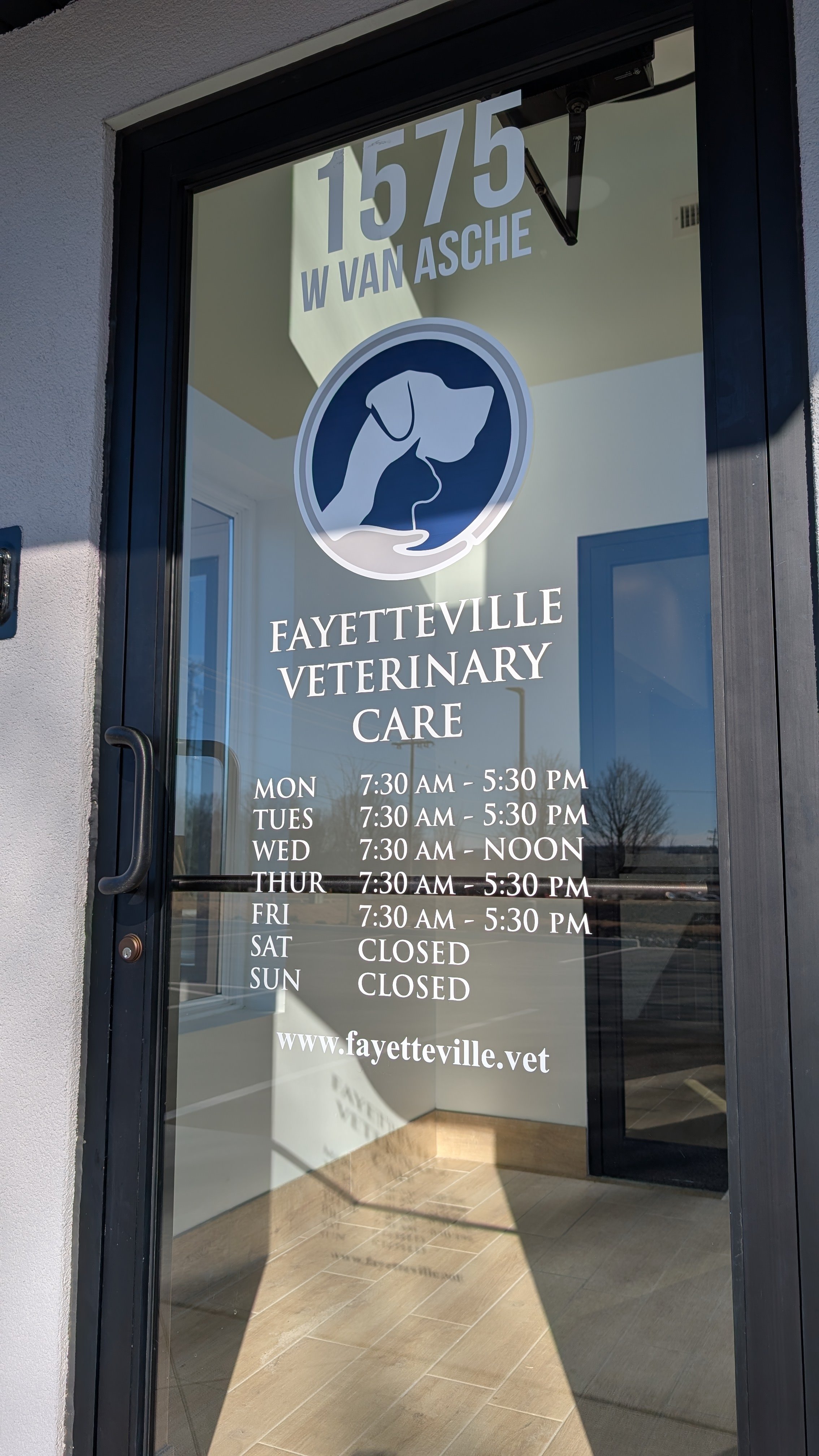 A sign displaying Fayetteville Veterinary Care 1575 W Van Asche Dr, Fayetteville, AR, 72704