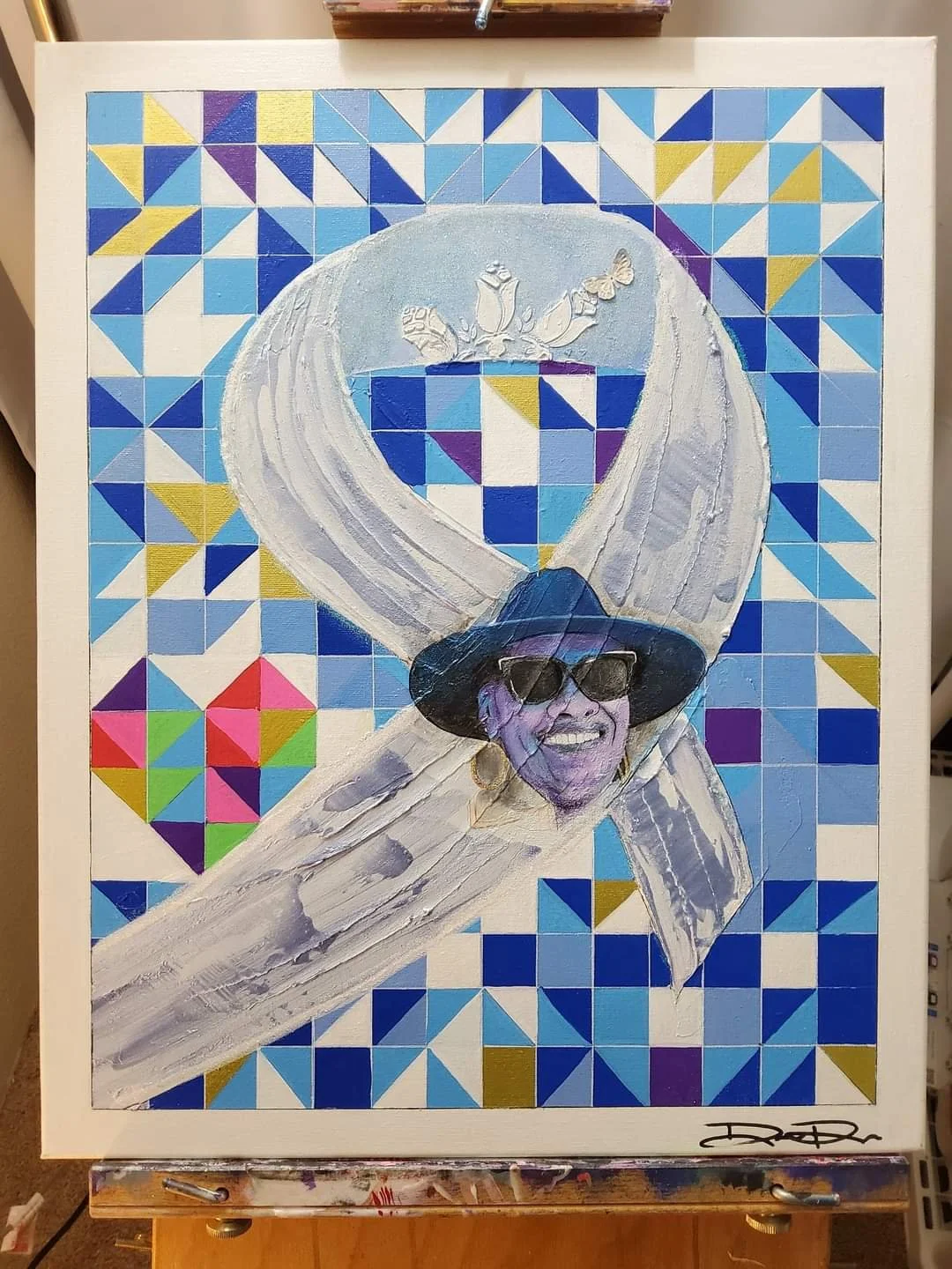 Colorful mosaic painting featuring abstract shapes and a face wearing sunglasses, set against a background of blue and multicolored geometric patterns.
