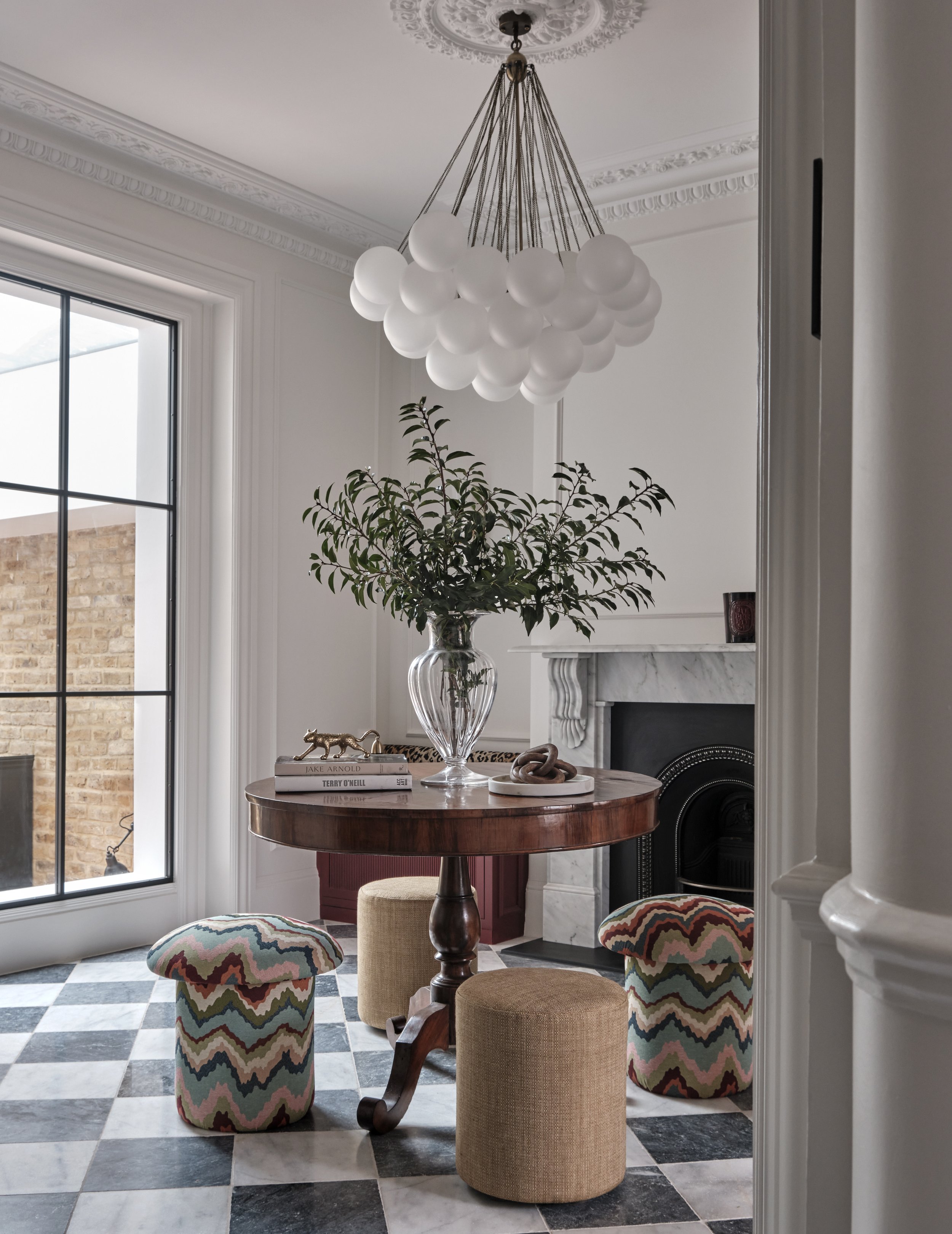 Stylish dining corner with round wooden table and modern chandelier