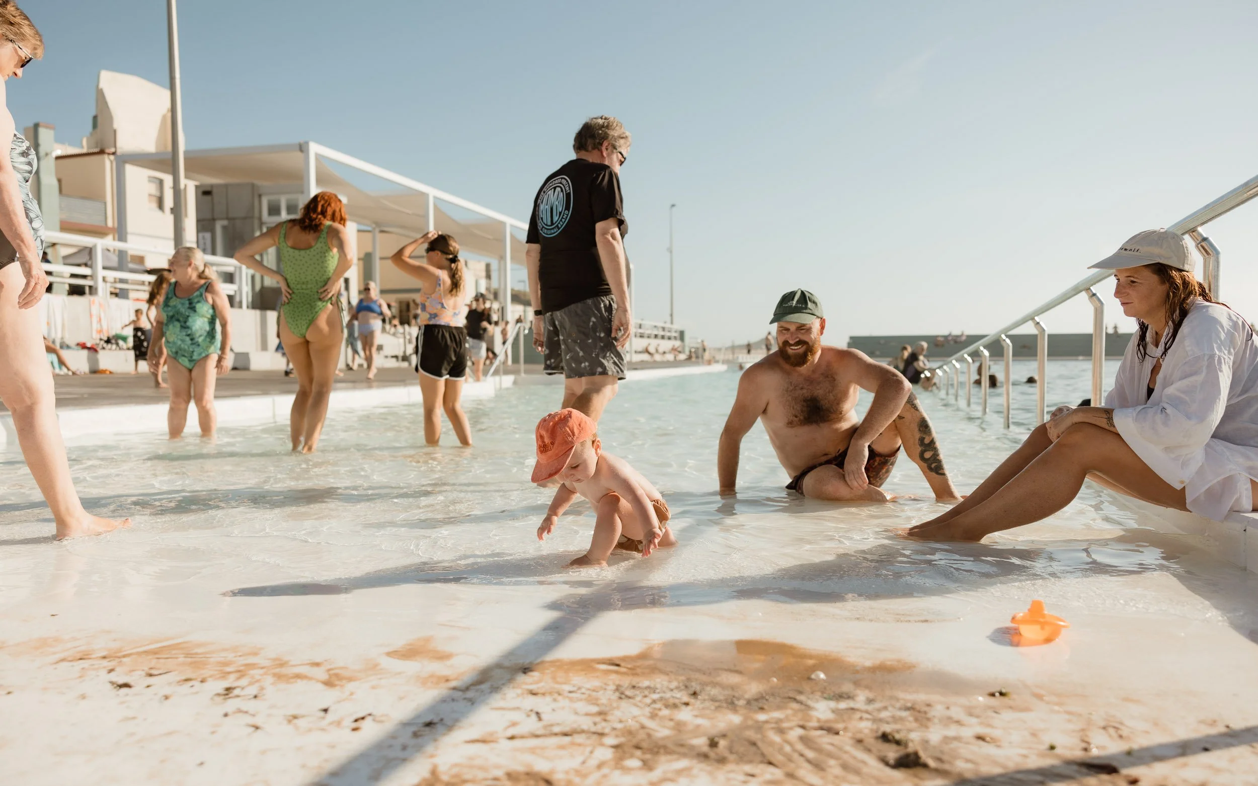 Newcastle documentary family photographer captures mum dad and baby at Newcastle Ocean Baths