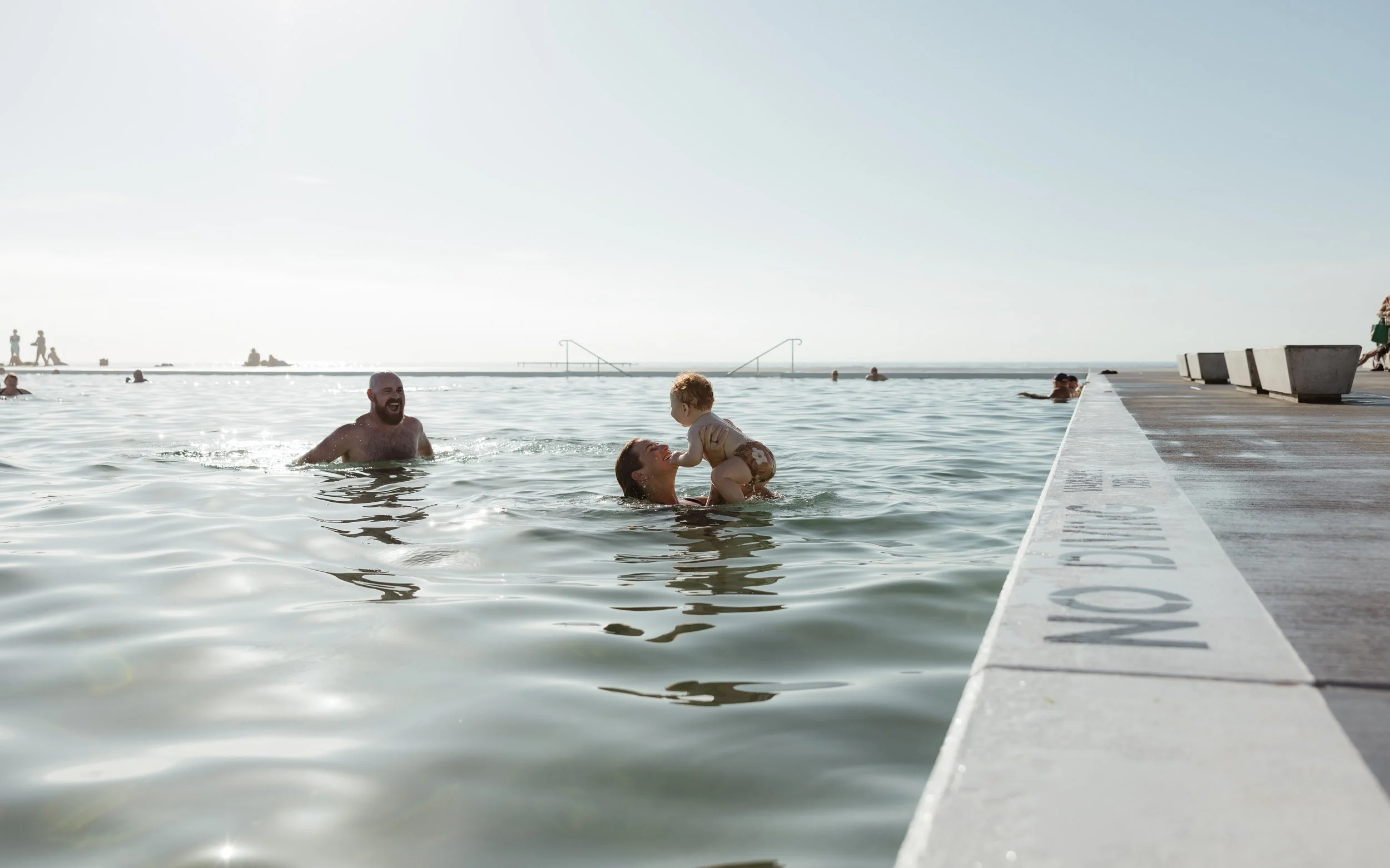 Young family enjoying summer at Newcastle Ocean Baths captured by Newcastle family photographer