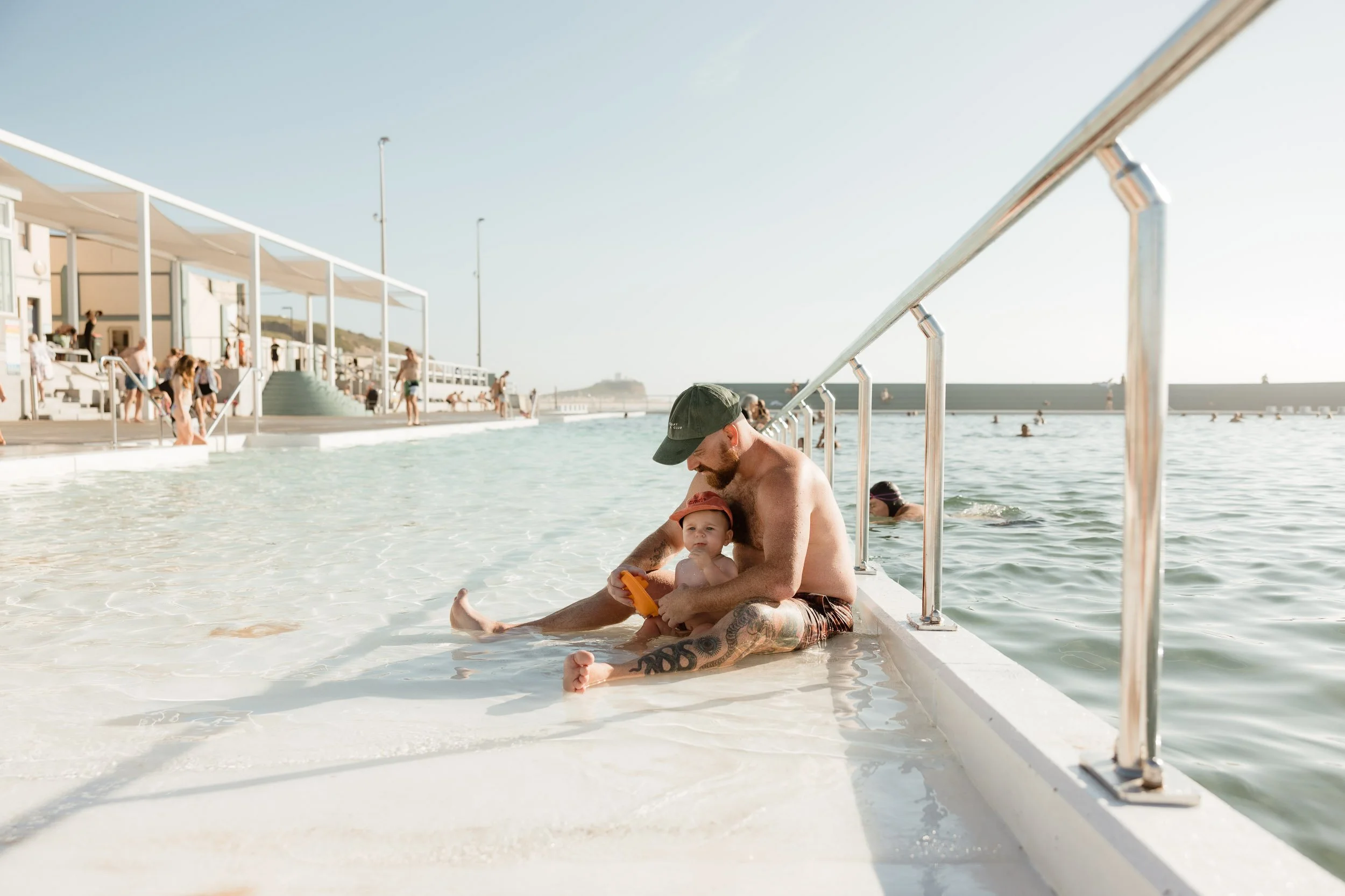 Young family enjoying summer at Newcastle Ocean Baths captured by Newcastle family photographer