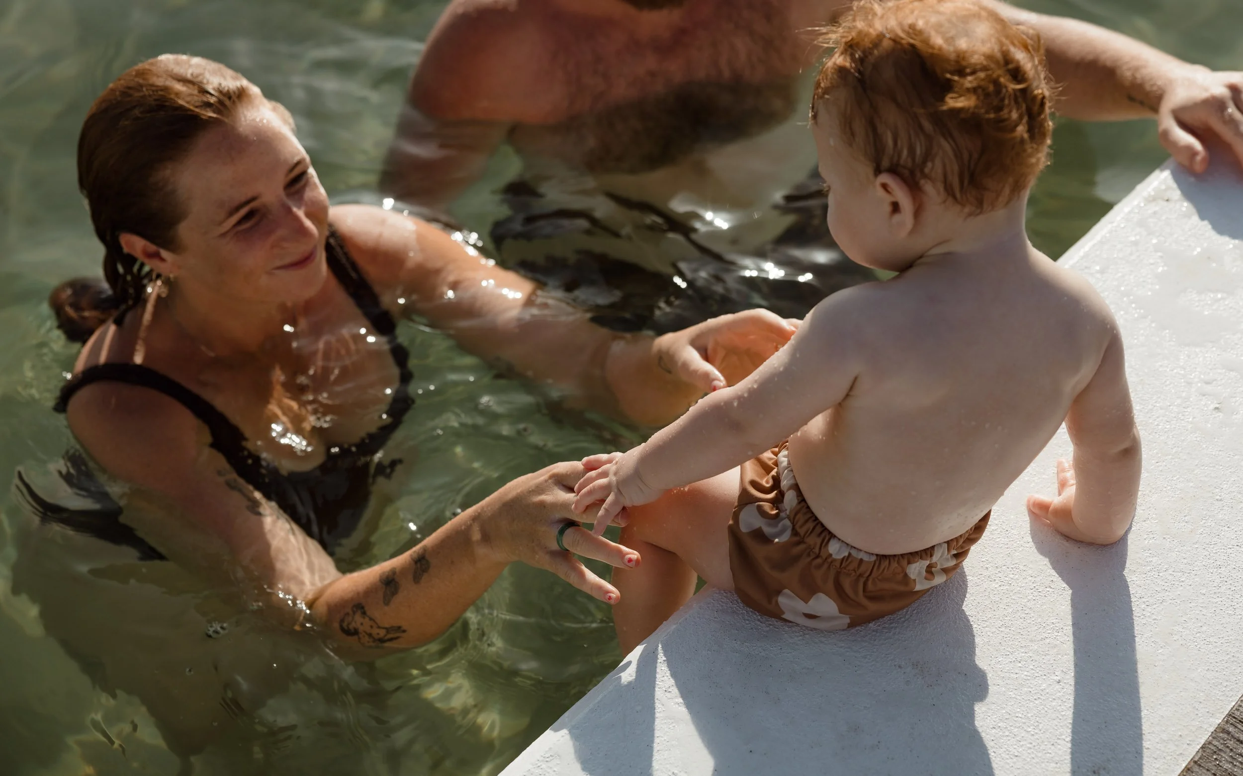 Newcastle documentary family photographer captures mum dad and baby at Newcastle Ocean Baths