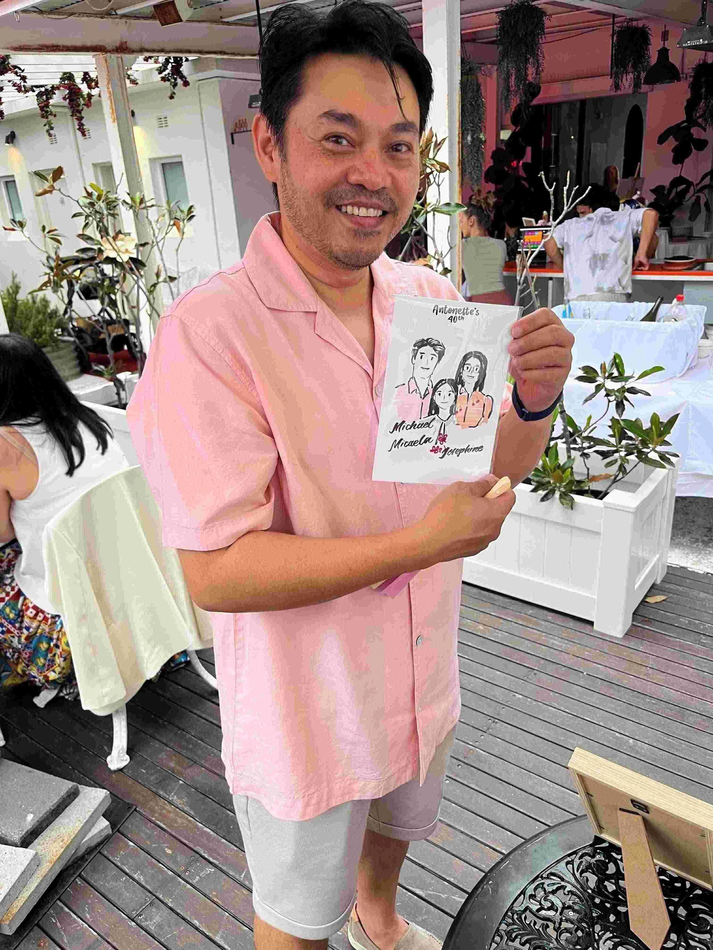 man-holding-live-drawing-at-birthday-party