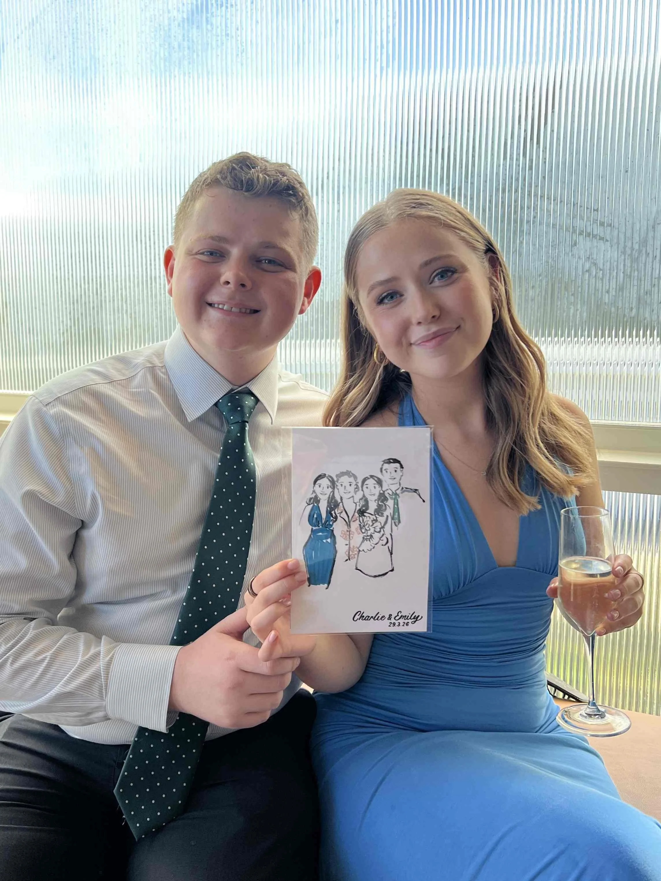 Brother and sister smiling while holding their hand-drawn wedding portraits during a celebration in Sydney