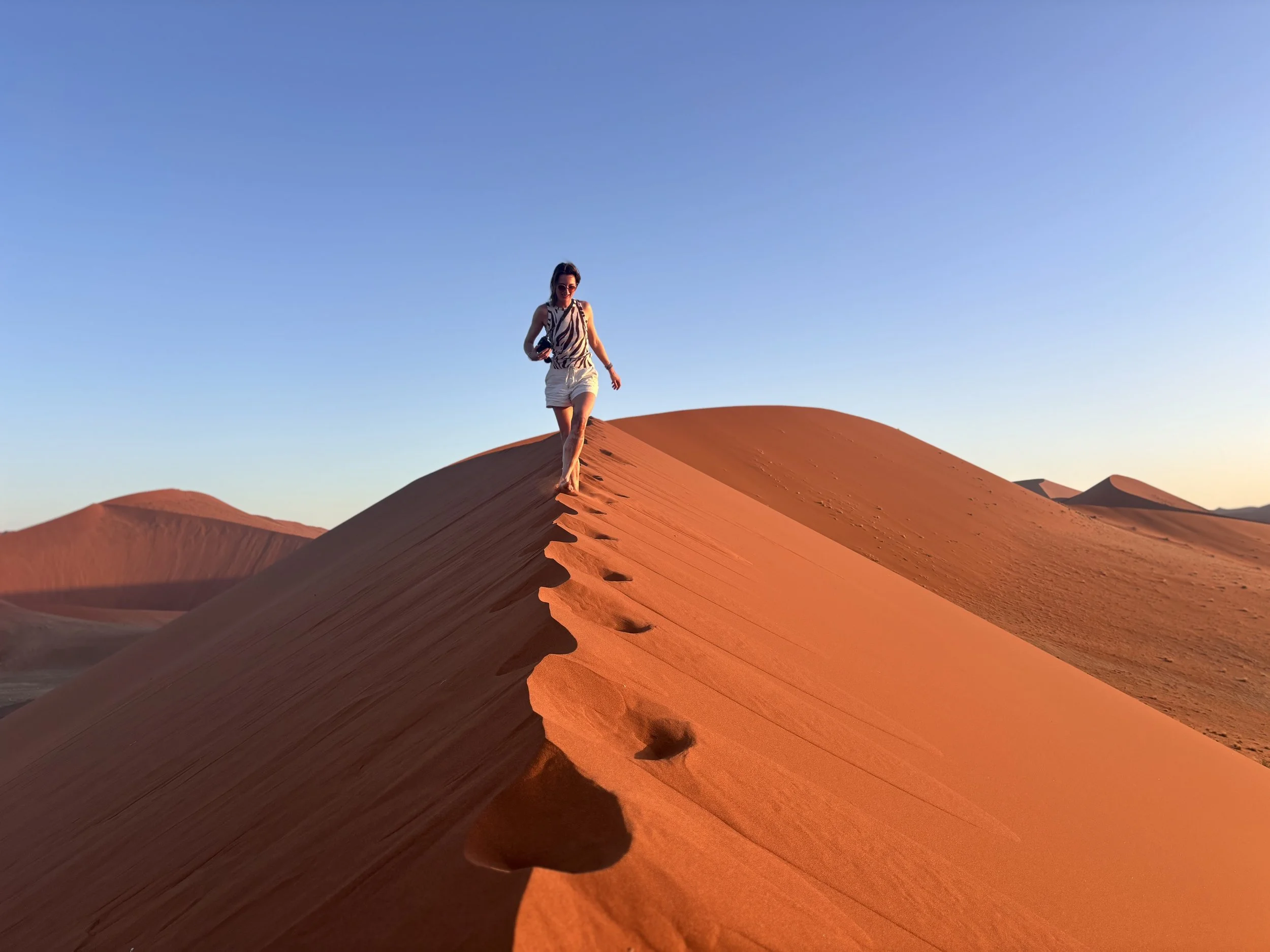 Climbing sand dunes in Sossusvlei during Namibia road trip itinerary