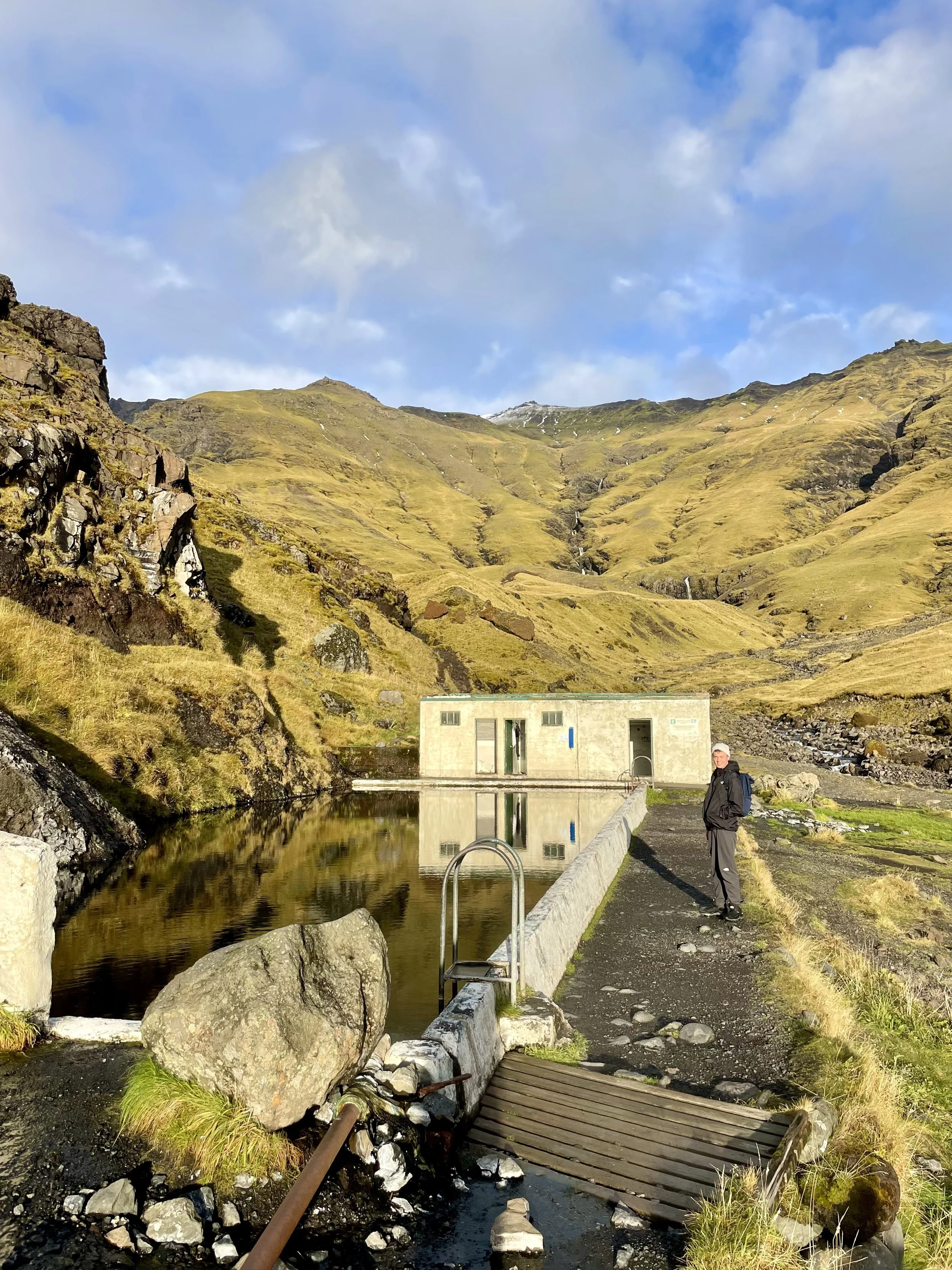 Traveler exploring Iceland’s natural wonders during a 2-week road trip itinerary. Find natural hot springs in Iceland
