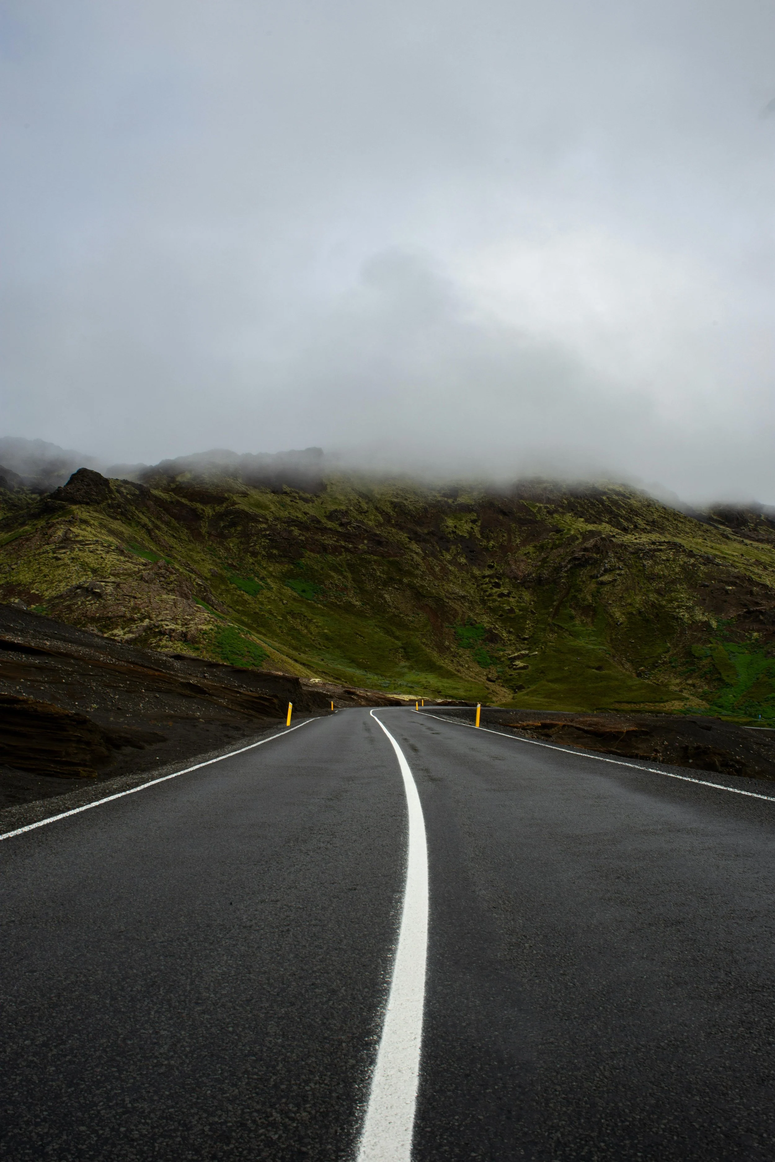 View of Iceland’s open road surrounded by mountains and lava fields, part of a 2-week Ring Road travel guide.