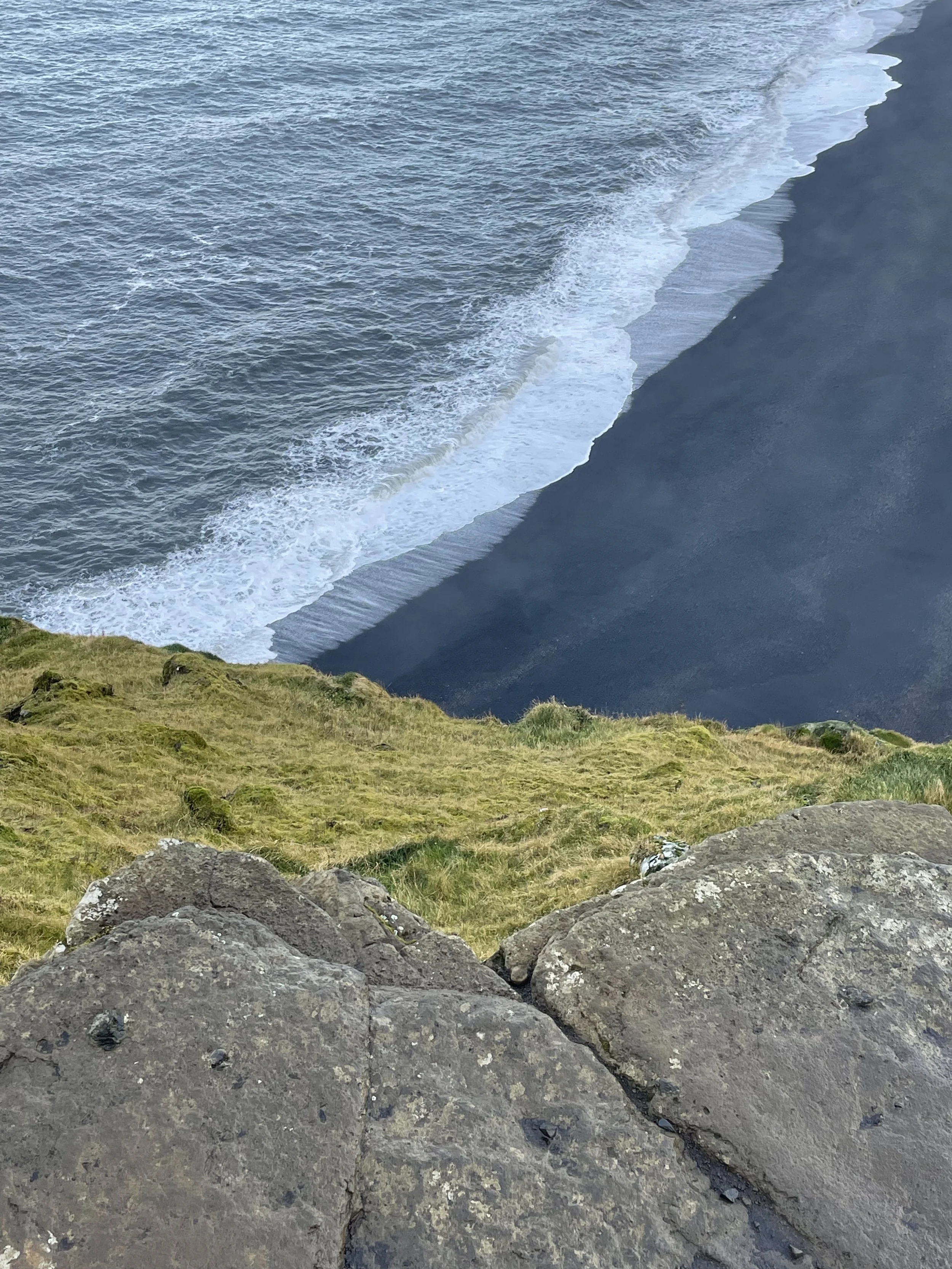 Black sand beach at Reynisfjara with basalt columns — dramatic coastline stop in the Iceland road trip.