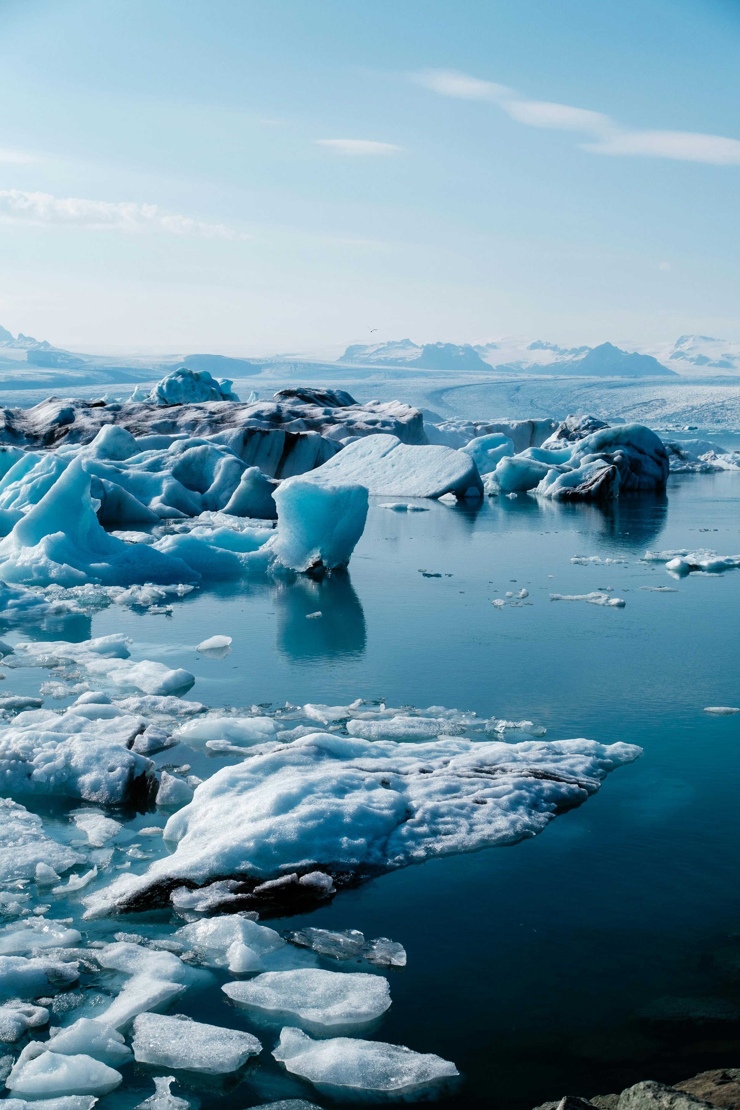 Glacier lagoon Jökulsárlón with icebergs drifting, and Diamond Beach’s ice chunks — iconic landscape in Iceland roadtrip.