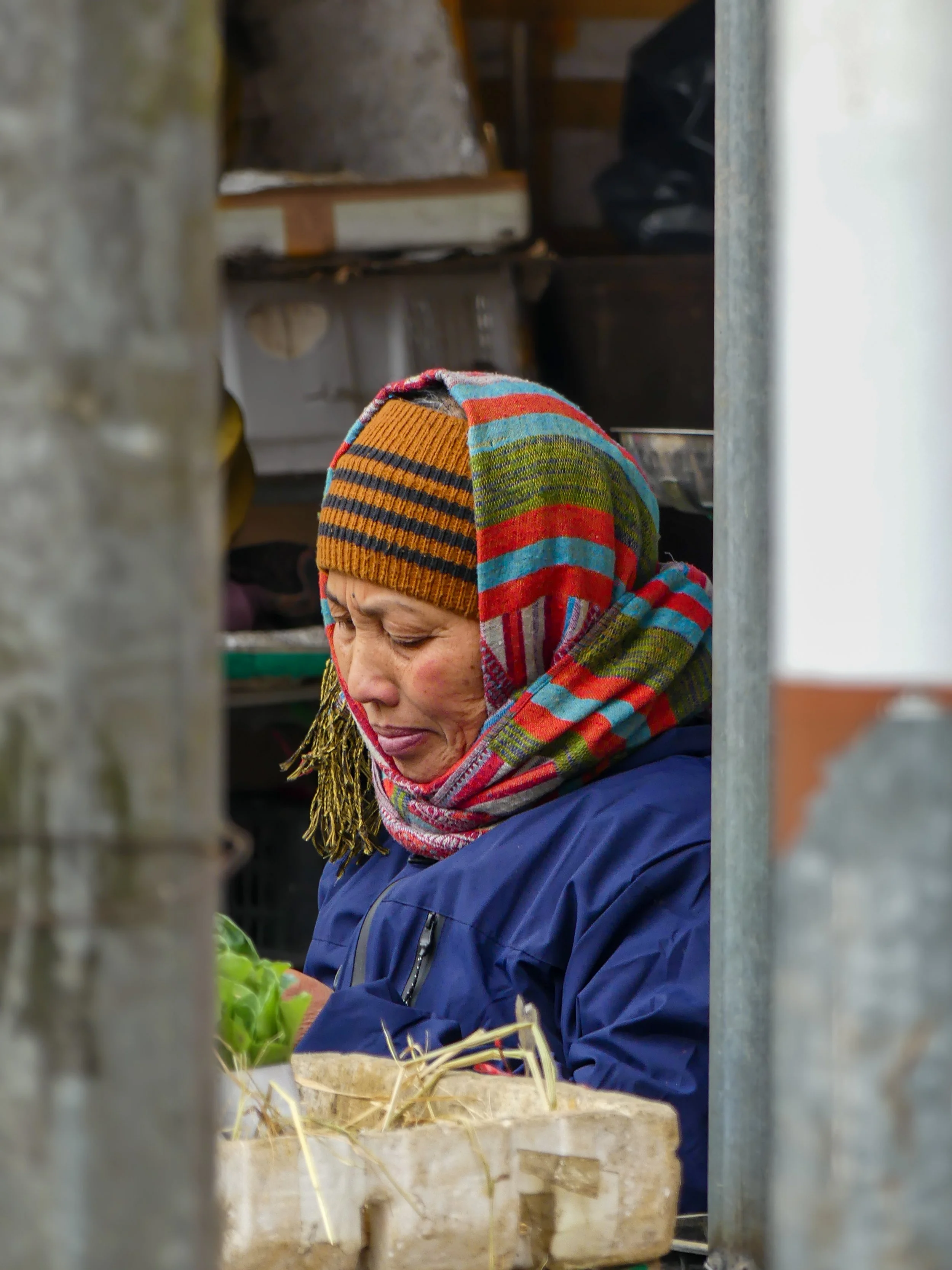 Person in colorful scarf looking down indoors.