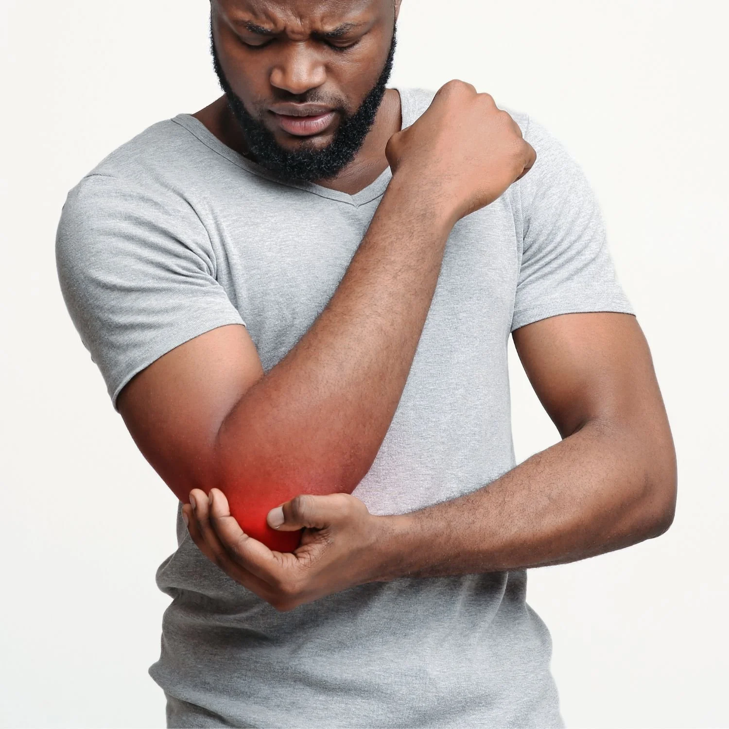A man wearing a gray T-shirt is holding his elbow and appears to be experiencing pain, indicated by redness on the inside of his elbow.