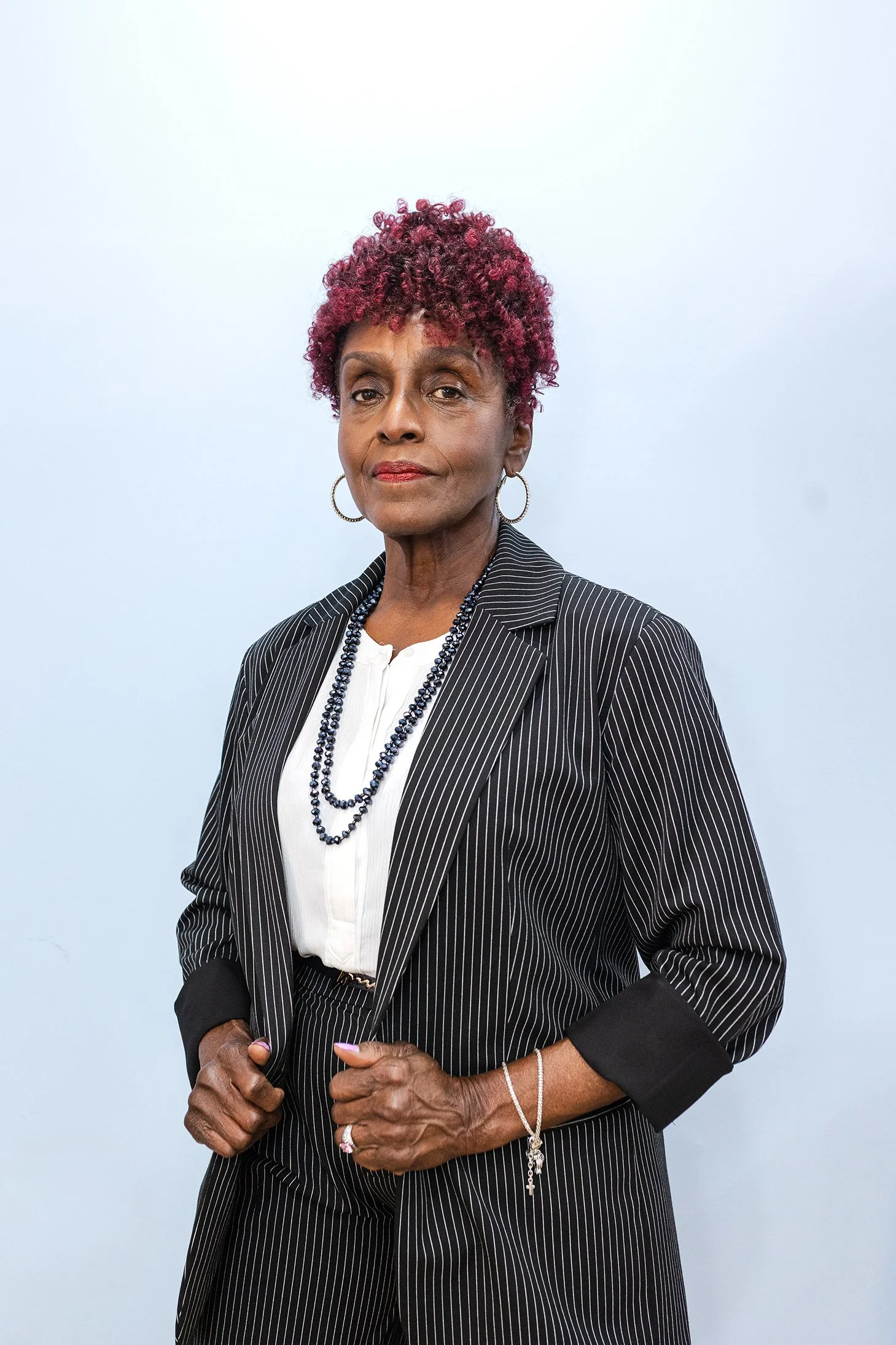 Detroit Entrepreneur Ava Jackson standing holding her blazer looking at the camera with fierce eyes