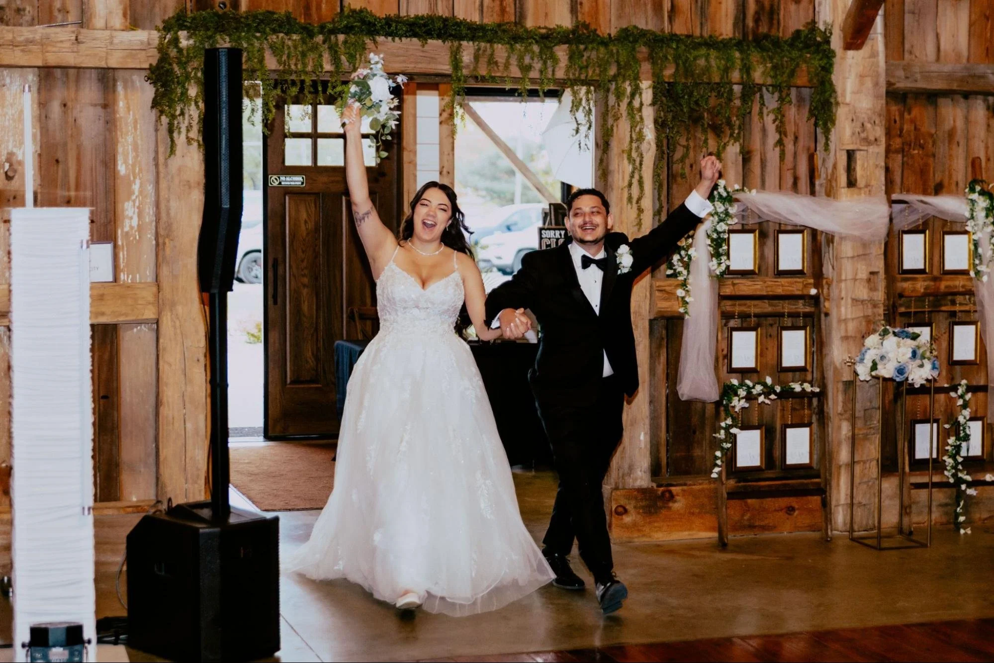 Detroit wedding photographer capturing the bride and groom making their grand entrance into their rustic barn wedding reception.