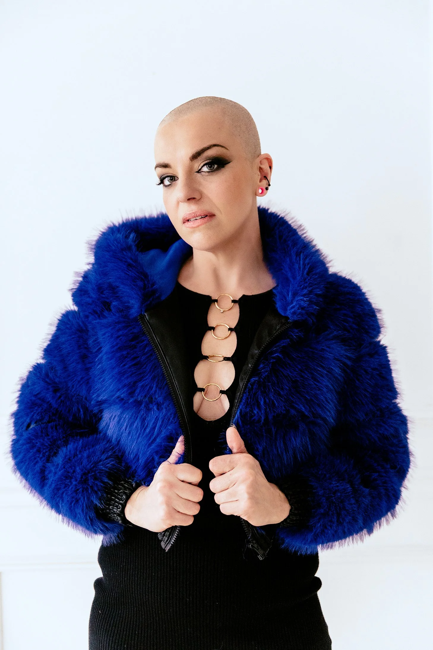 Creative portrait of a woman in a black dress and blue fur jacket photographed in Pontiac, Michigan studio