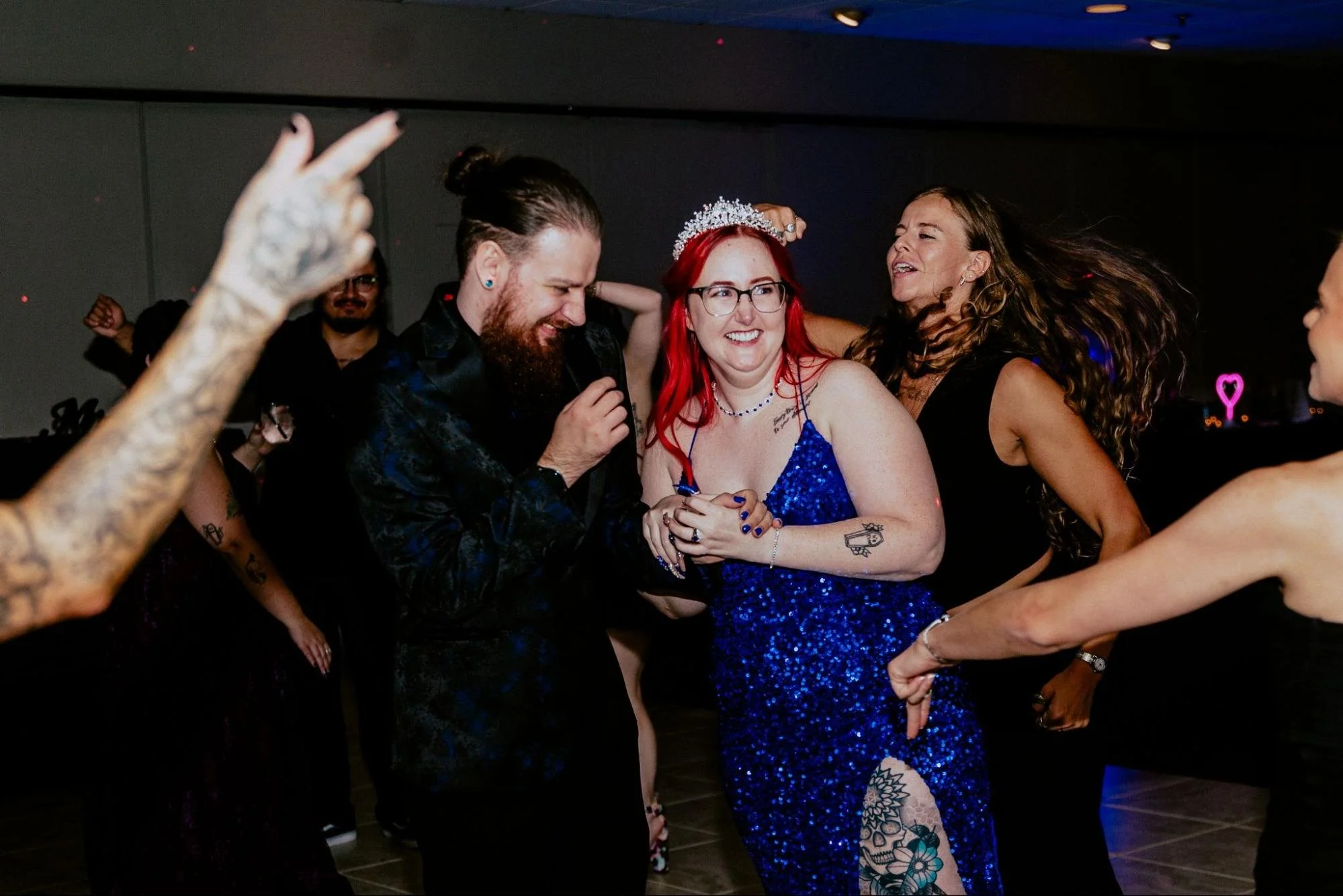 Detroit wedding photographer capturing a lively wedding reception with the newlyweds and guests dancing and celebrating together.