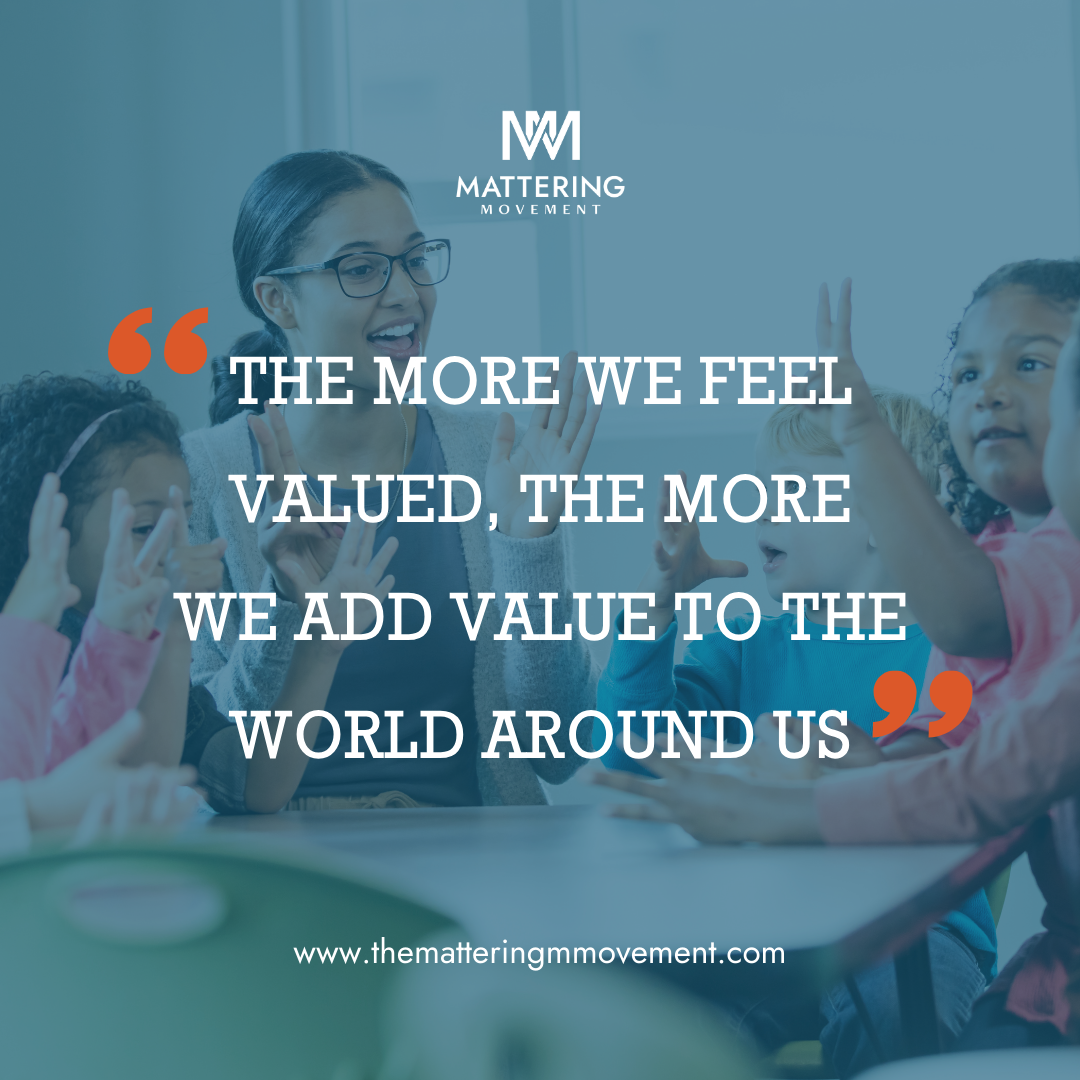 A woman with glasses and children gathered around a table in a classroom or educational setting, engaging in a discussion or activity, with a motivational quote overlayed on the image.