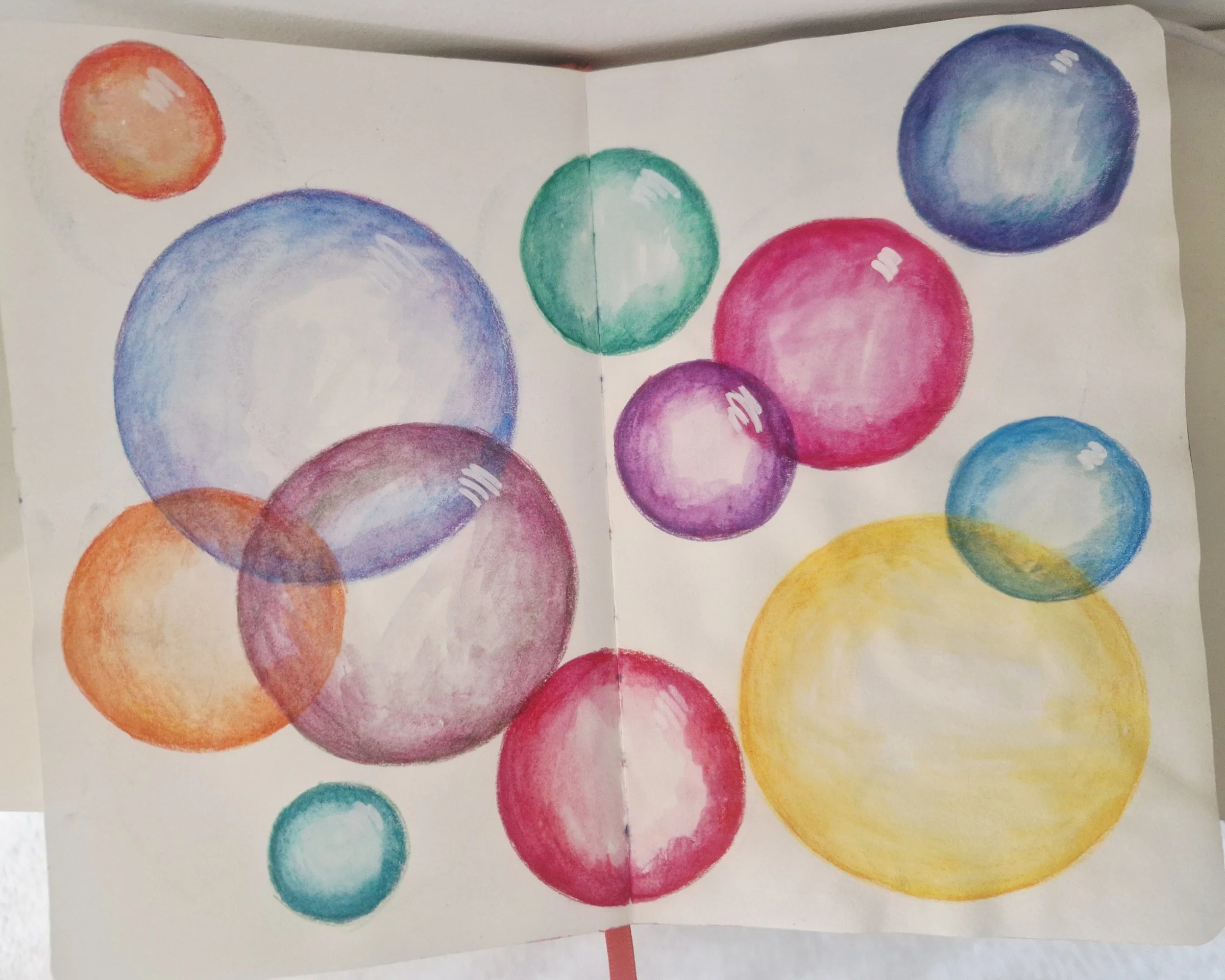 A page from a sketchbook showing overlapping circles in watercolour pencil