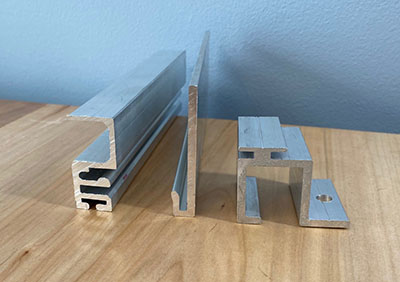 Aluminum extrusion profiles and metal brackets on a wooden surface.
