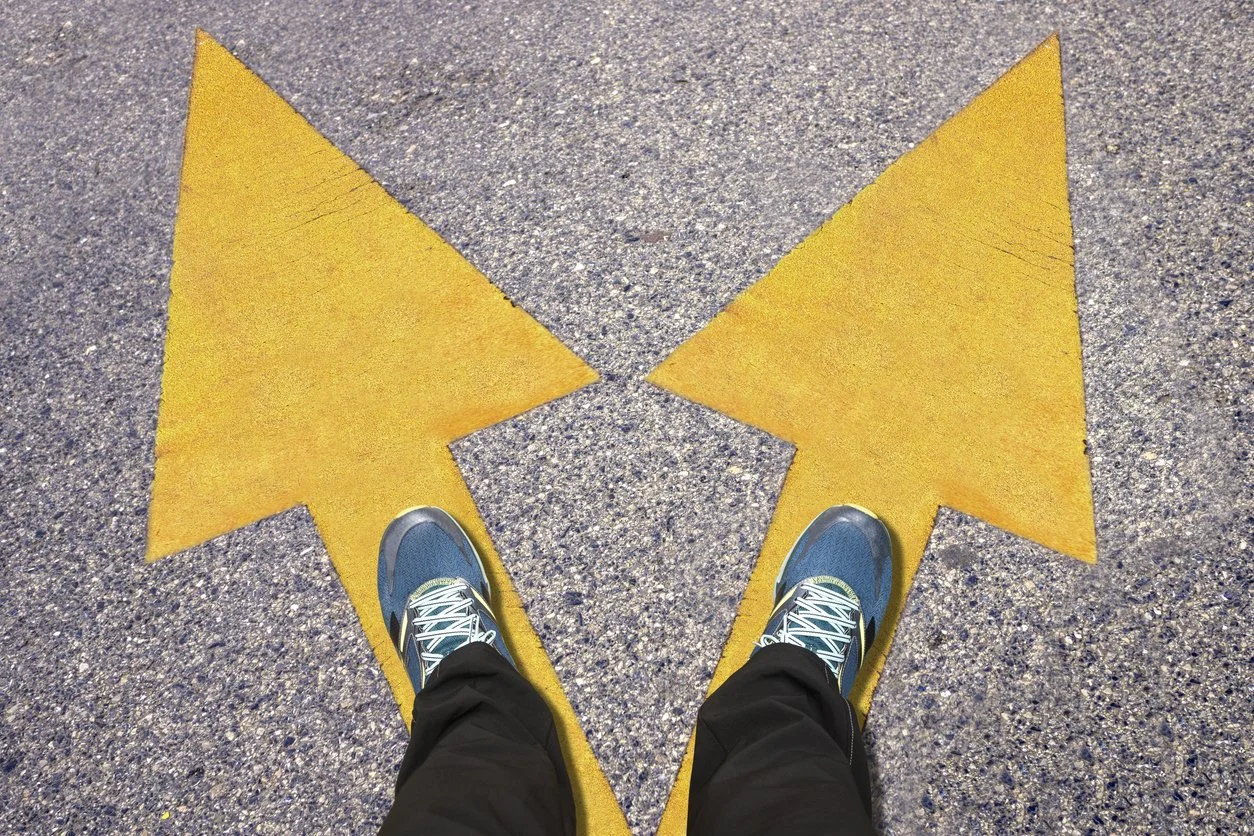 Person standing on top of two dual arrows