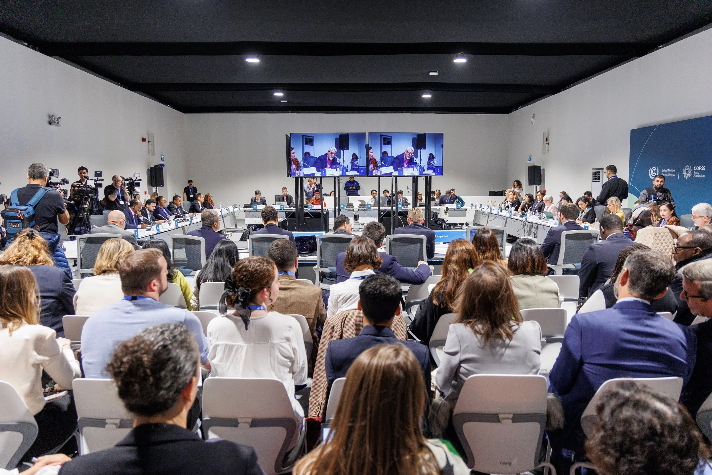 A large conference room filled with dozens of people attending a meeting or panel discussion - www.brentkerrigan.com - photo by Kiara Worth