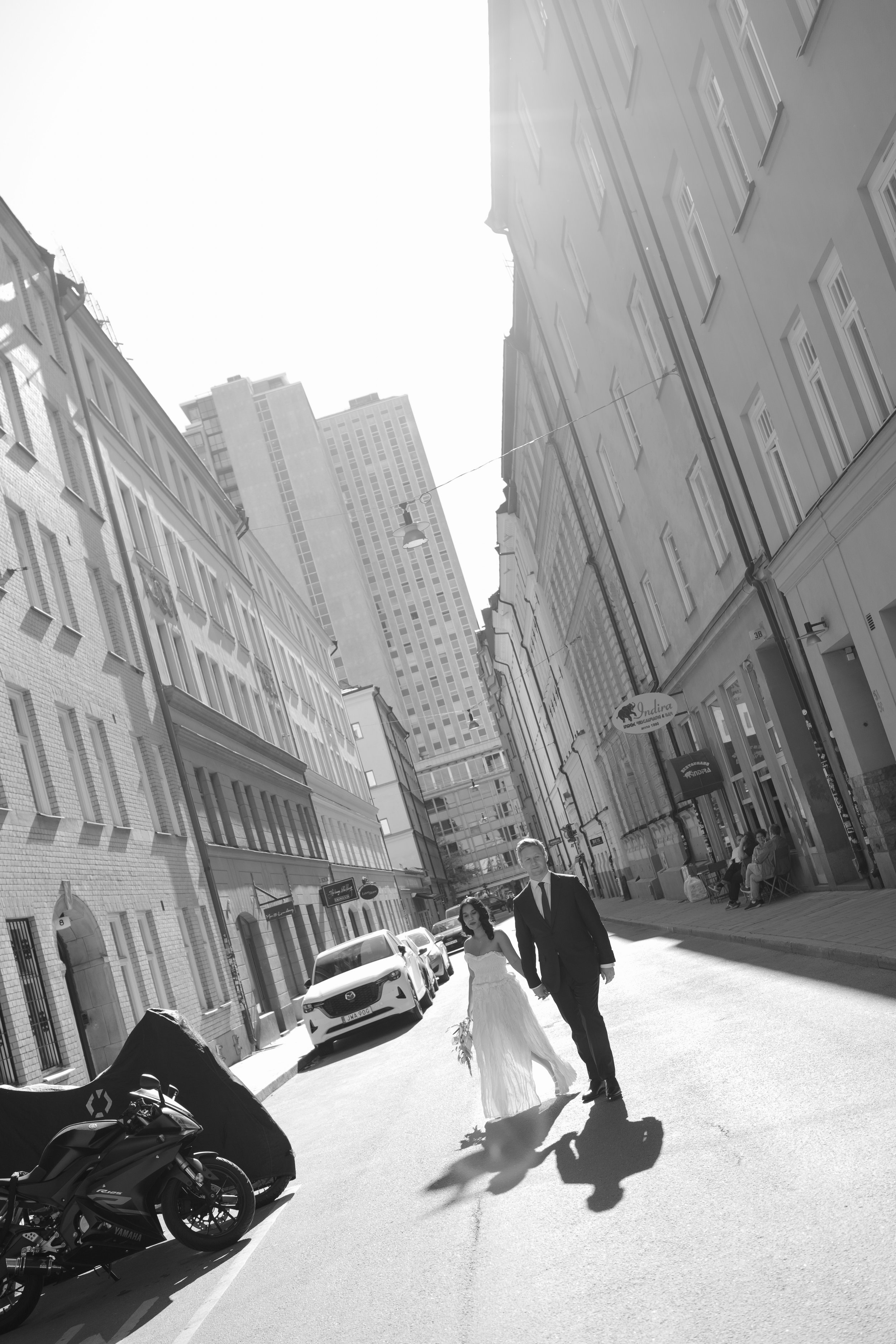 Wedding photo of couple walking down a street after their elopement wedding in Stockholm.