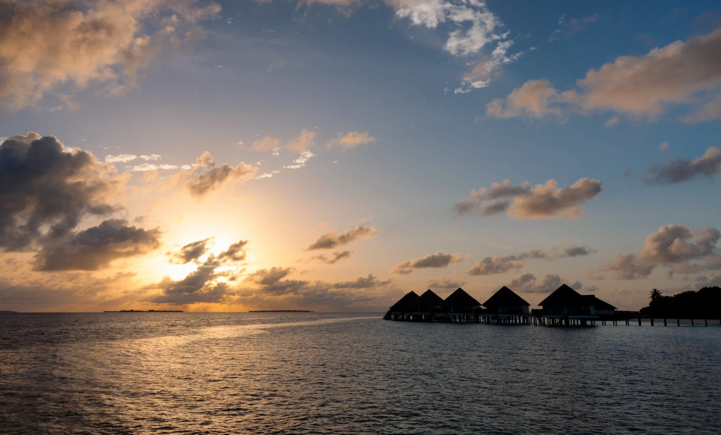 Sunset over overwater bungalows in the Maldives