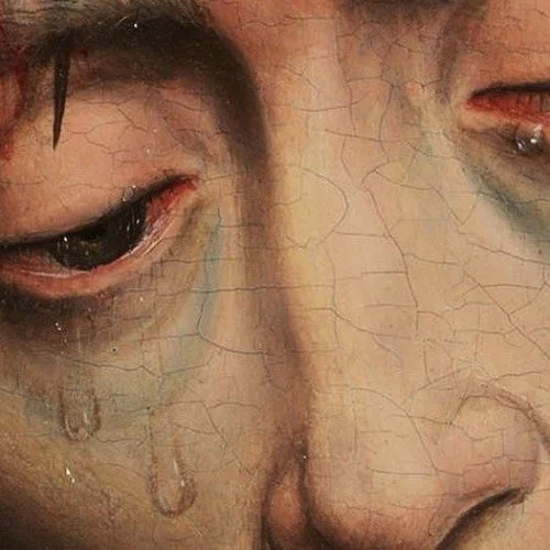 Close-up of a person's face with tears running down their cheeks.