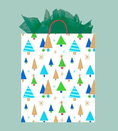 A holiday-themed gift bag with a pattern of Christmas trees in blue, brown, and green, decorated with stars, snowflakes, and ornaments, with green tissue paper inside.