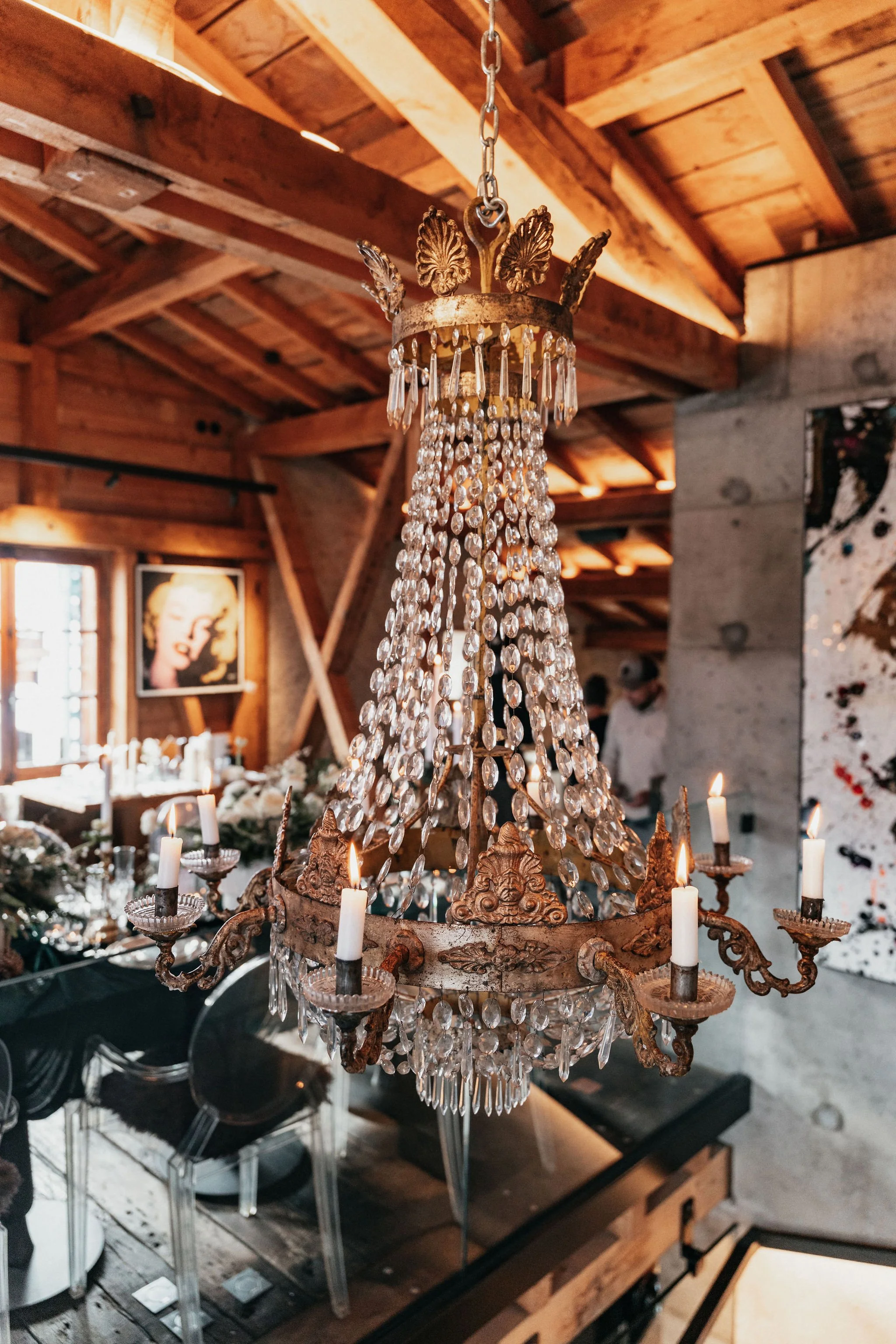 Un lustre en cristal avec bougies dans un intérieur en bois, décoré pour une occasion spéciale.