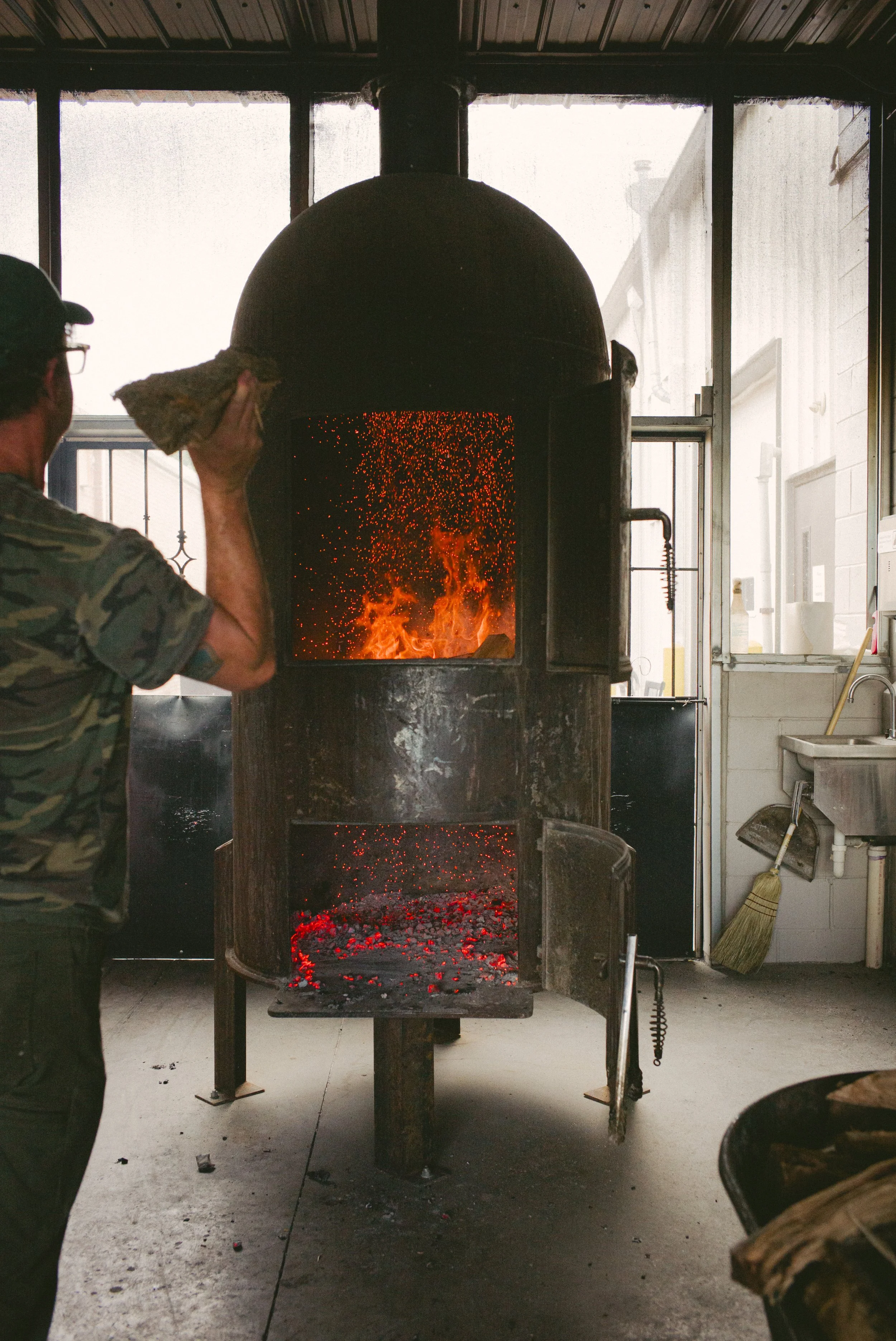 Real wood is tossed into fire box to make charcoal for the pit.